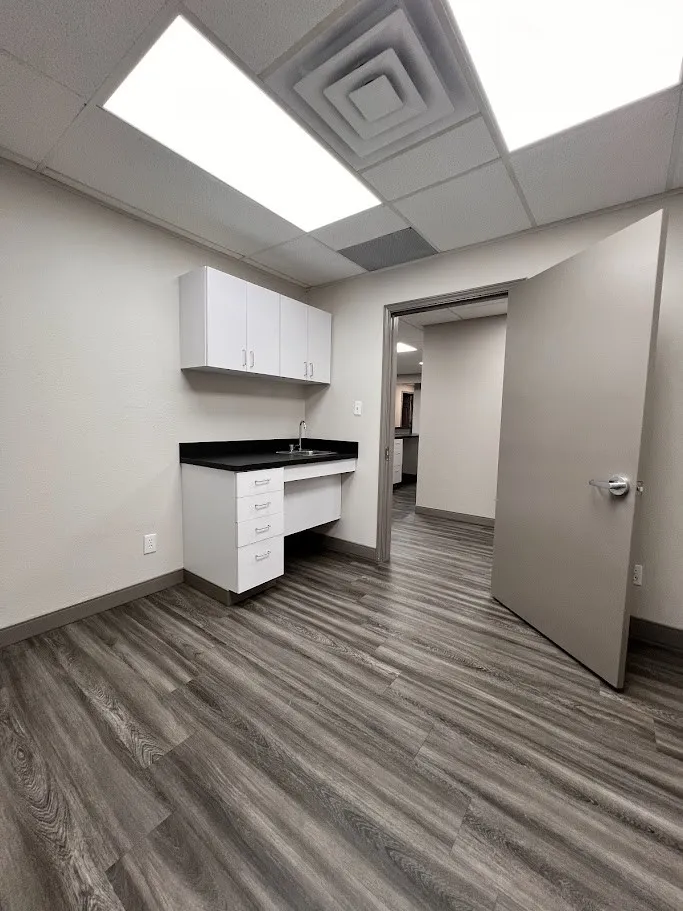 Unfurnished office featuring a paneled ceiling and dark wood-style floors