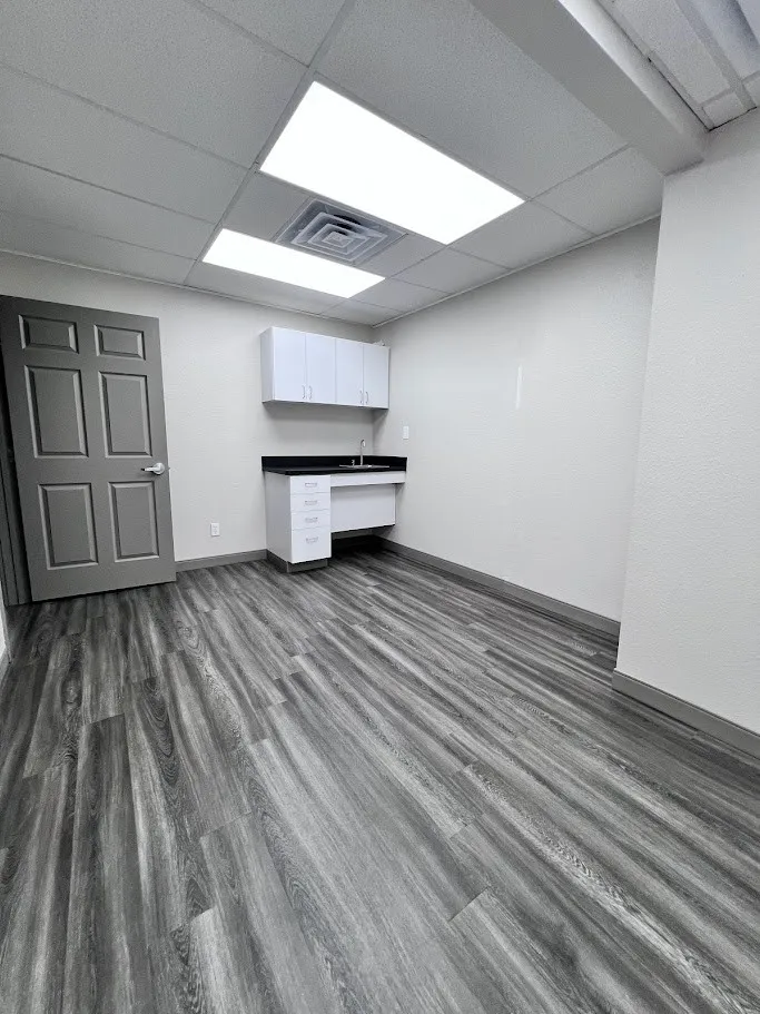 Unfurnished office featuring dark wood-type flooring and a paneled ceiling