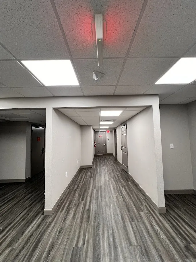 Finished basement with dark wood-style flooring and a paneled ceiling
