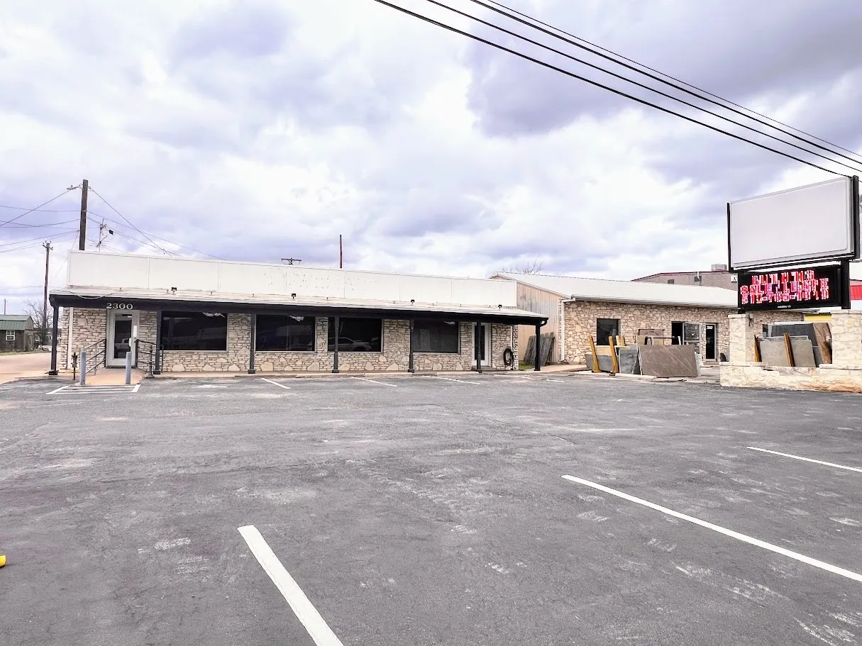 View of building exterior with uncovered parking