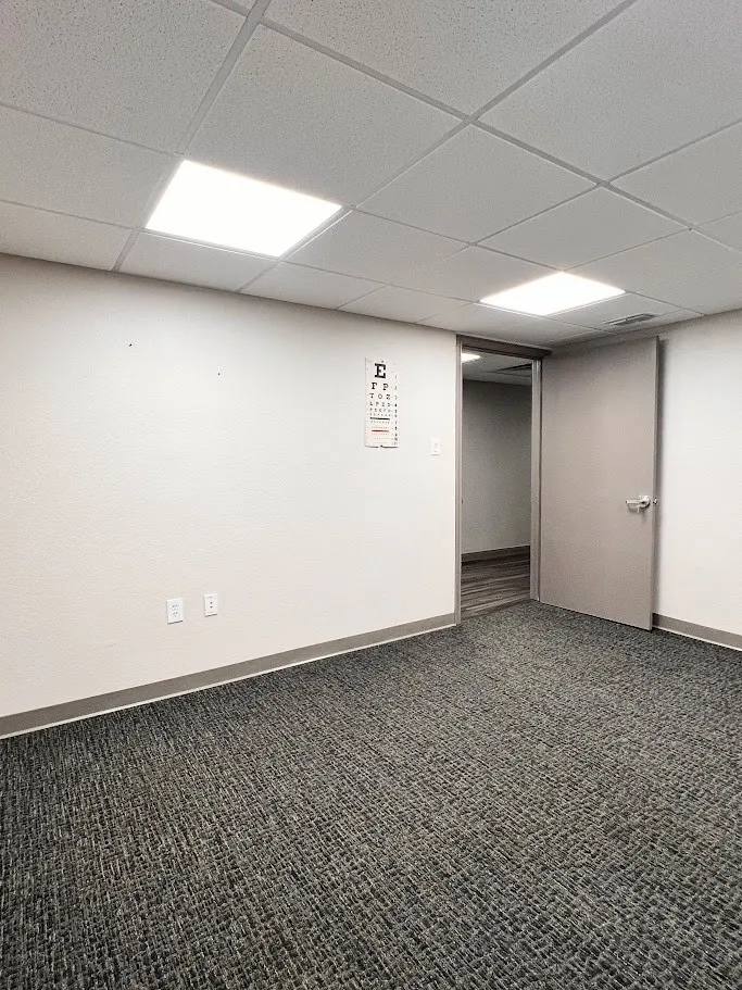 Spare room featuring dark colored carpet and a paneled ceiling
