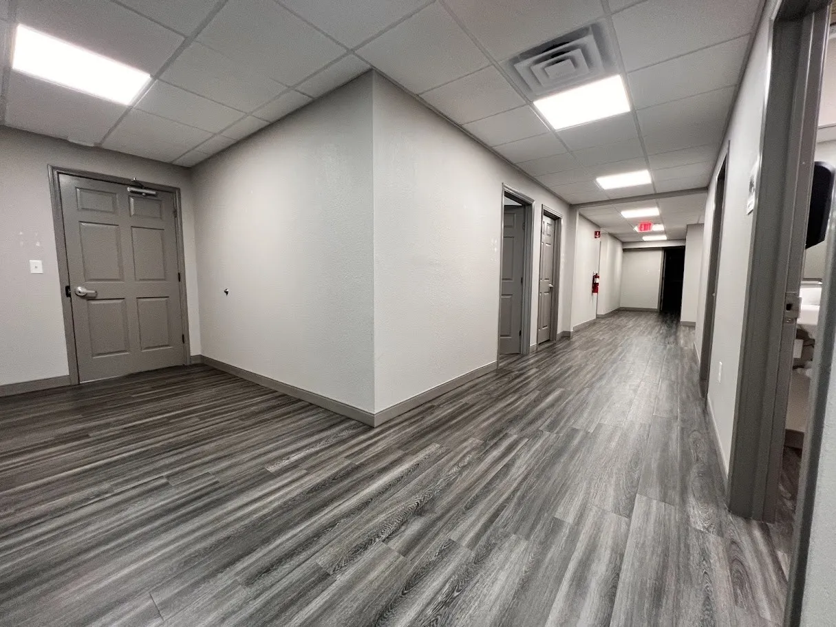 Hall featuring a paneled ceiling and dark wood finished floors