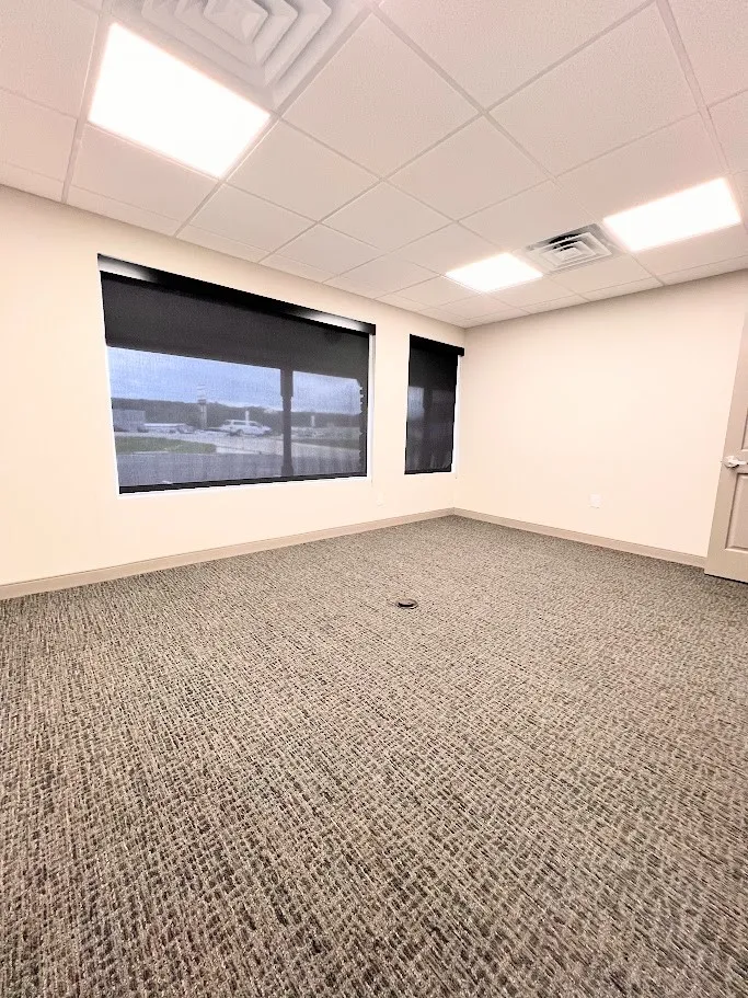 Empty room featuring carpet and a drop ceiling