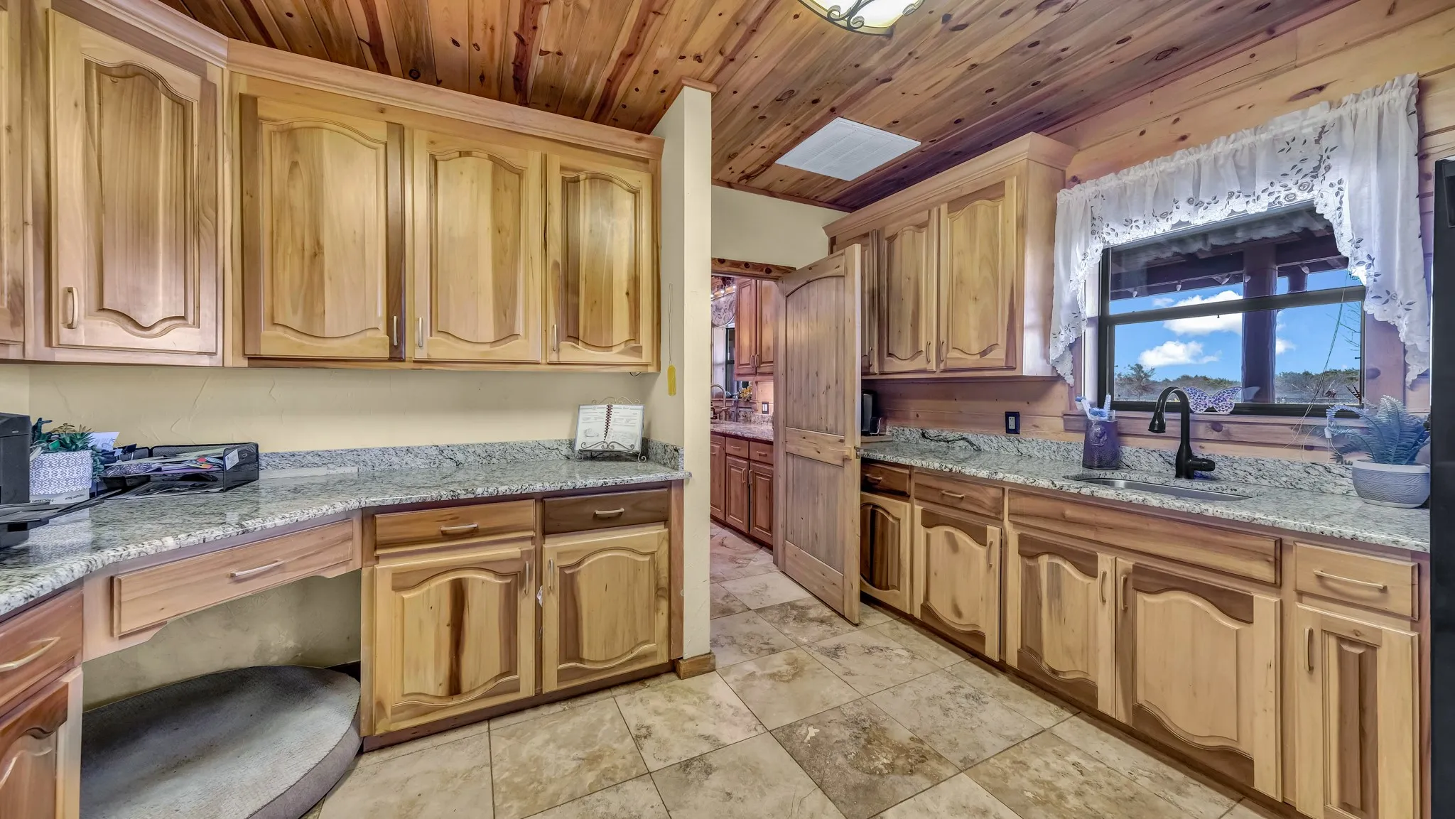 Laundry room in the main house has plenty of cabinet space, a sinki, and a desk area to boot!