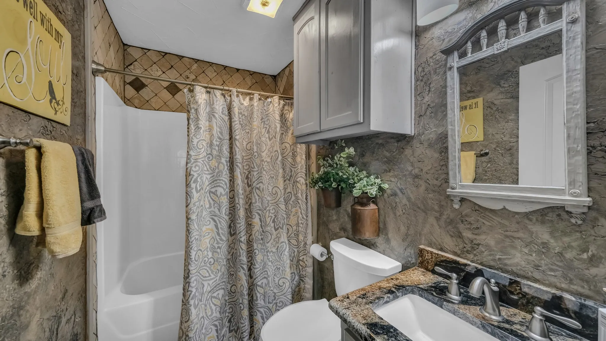 Upstairs barn bathroom has tub/shower combination, toilet, and sink area.
