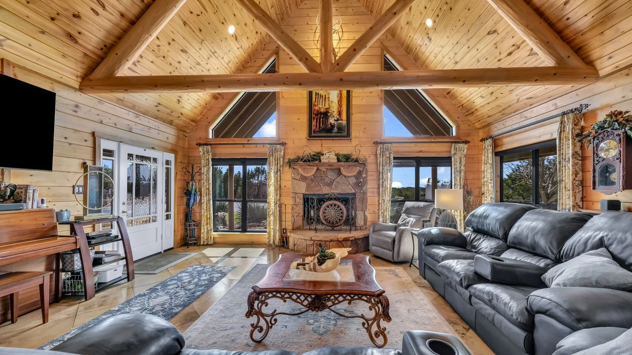 Huge triangular windows surrounding the stone, wood burning fireplace allow natural sunlight and the beauty of the outdoors in all day long.