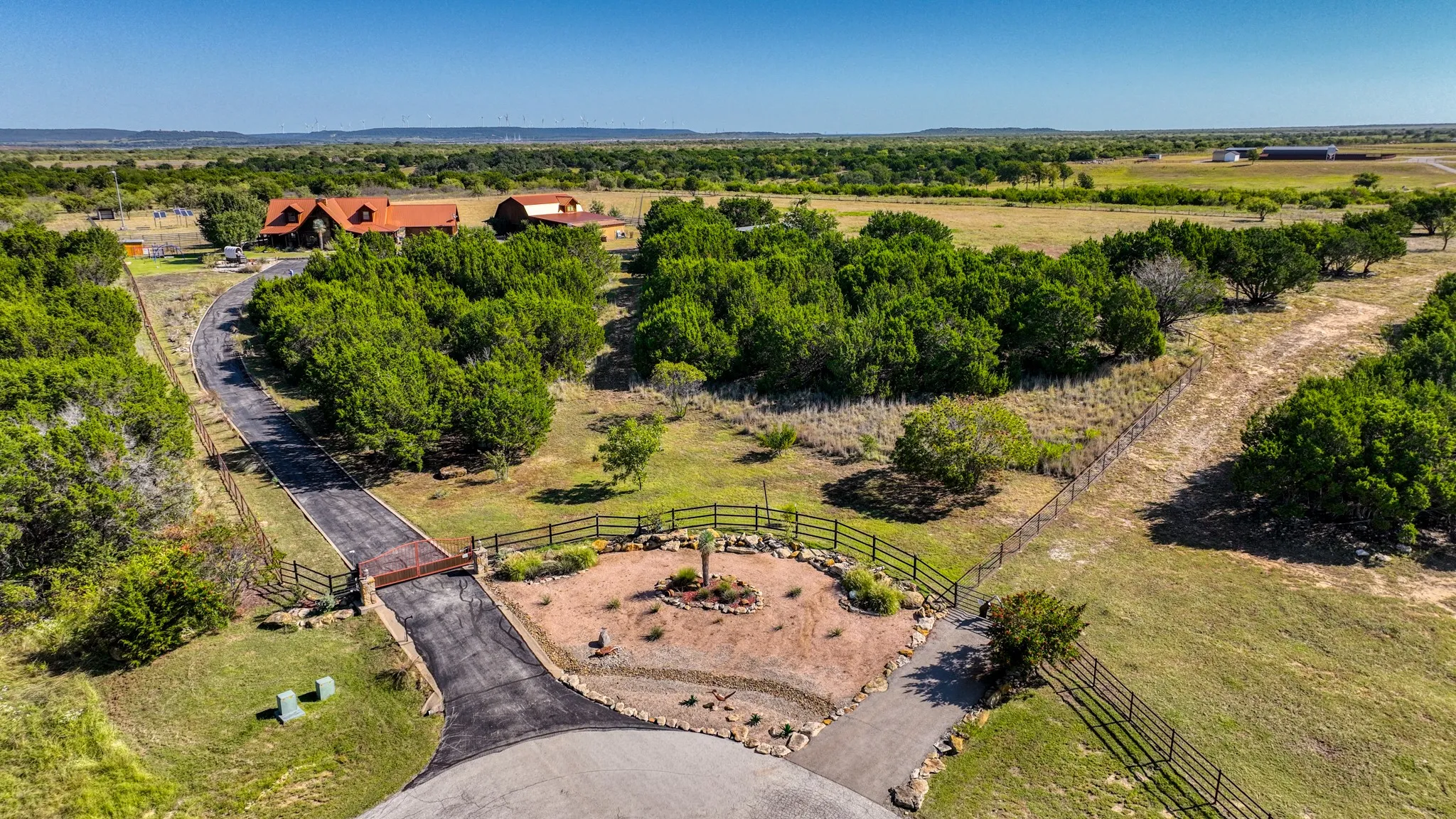 Gated and fully landscaped entrance. Property primarily has pipe fencing with cattleguard surrounding its perimeter.