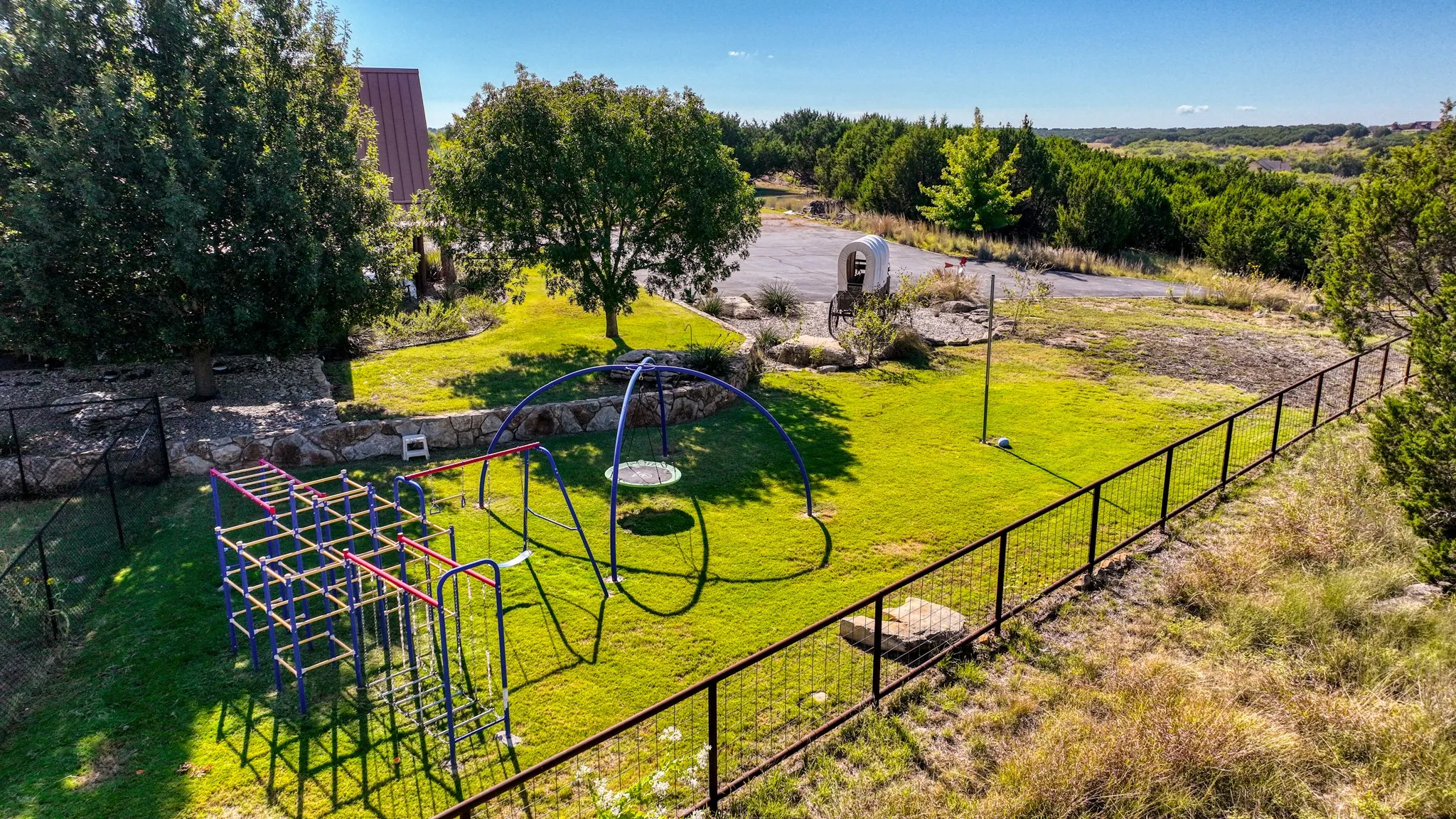 West side of this property has mature tree coverage and a stablizing metal play center for kids of all ages.