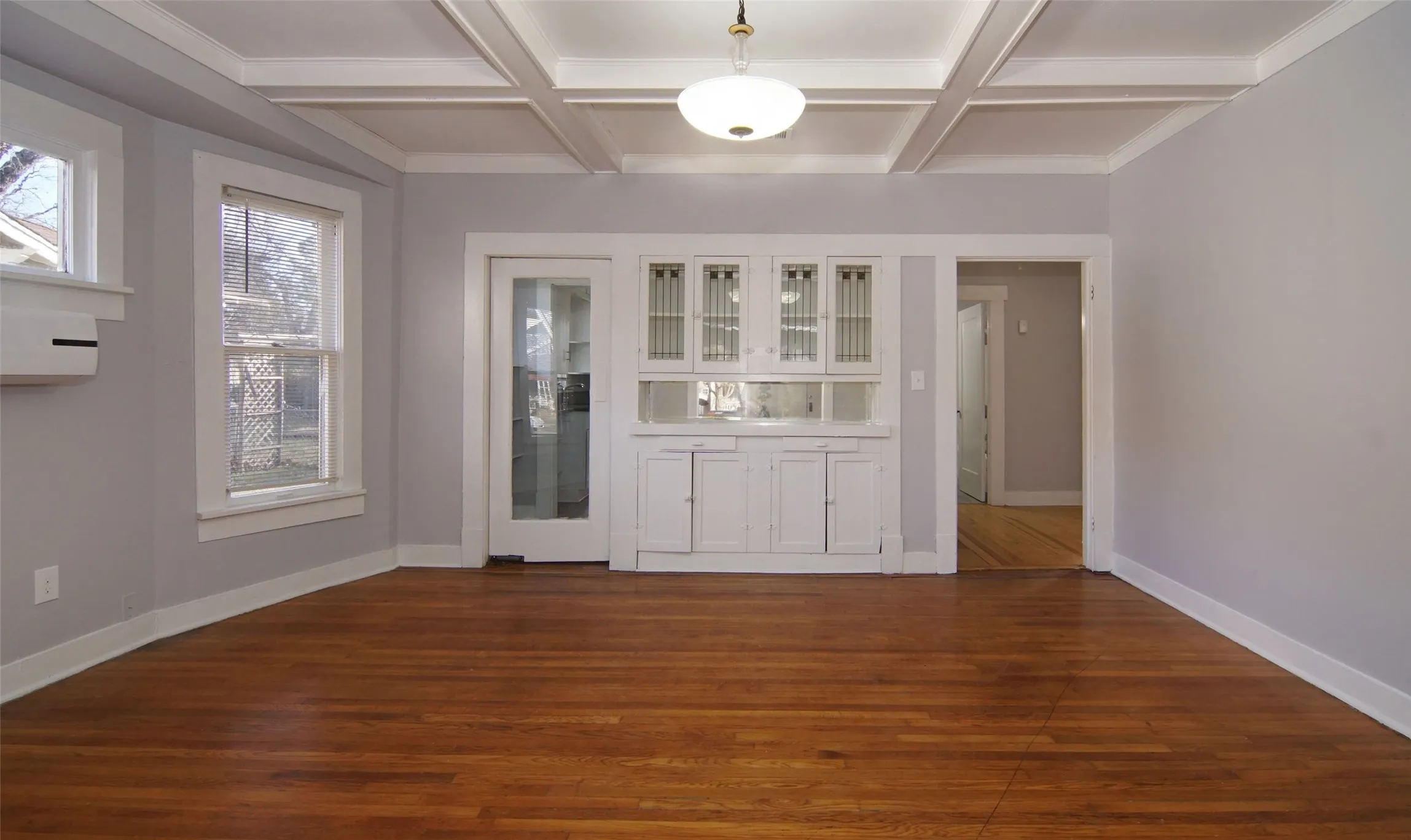 Dining room with butler's pantry, coffer ceilings, natural wood floors
