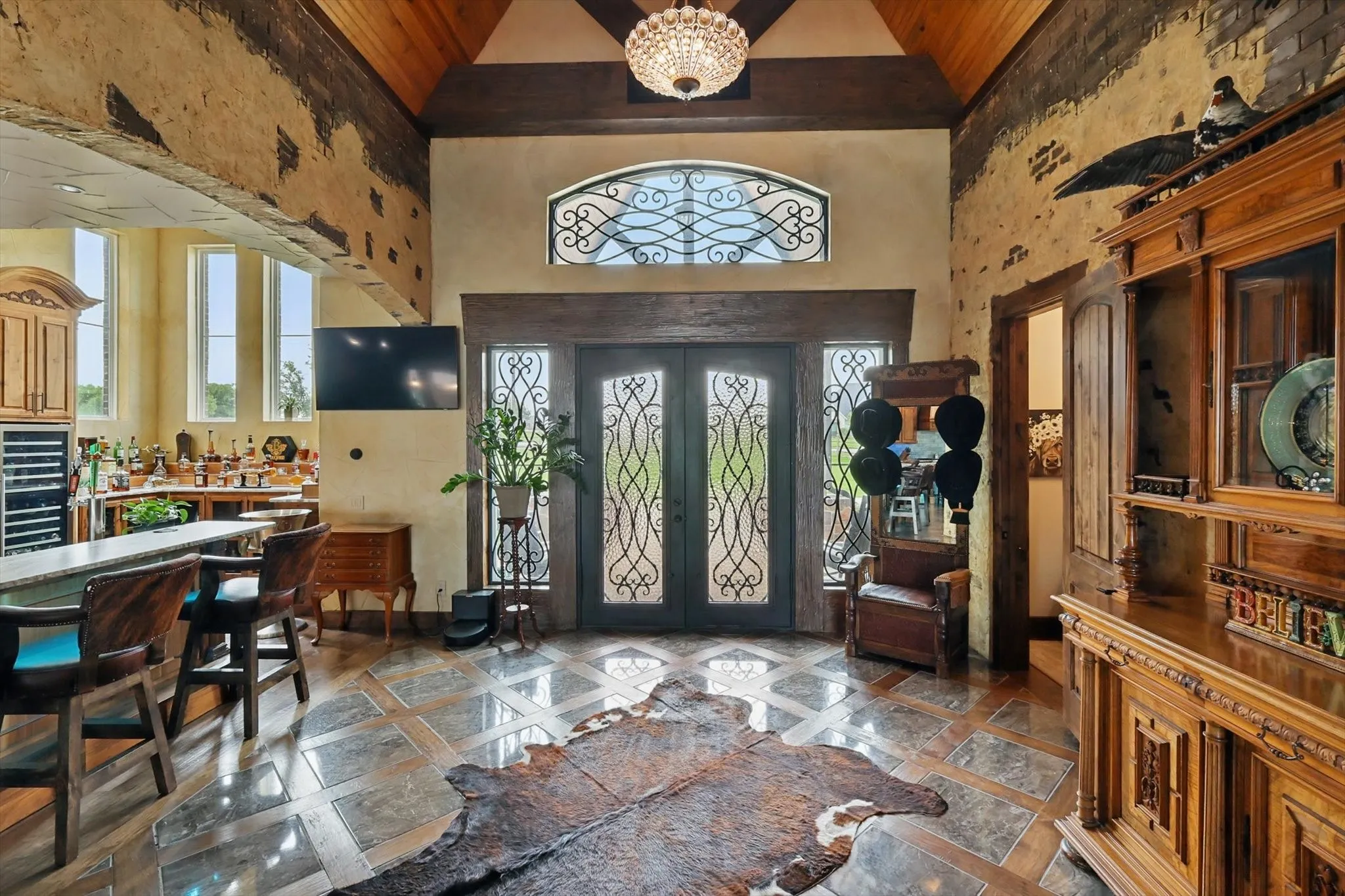 Foyer with french doors, inlaid floor details, healthy amount of natural light, and a high wood ceiling