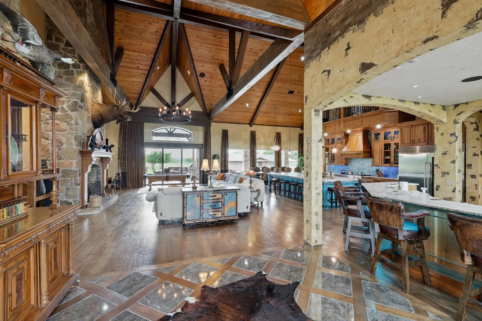 Living area with inlaid floor details, a high wood beamed ceiling, suspended lighting, a fireplace, and dark wood-style flooring