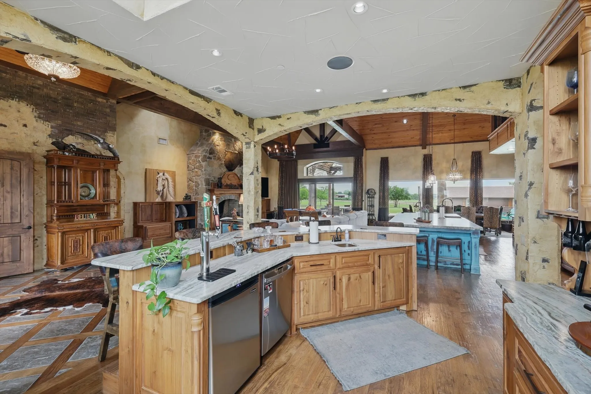 Kitchen with open floor plan, beamed ceiling, dishwasher, a chandelier, and light wood finish cabinets