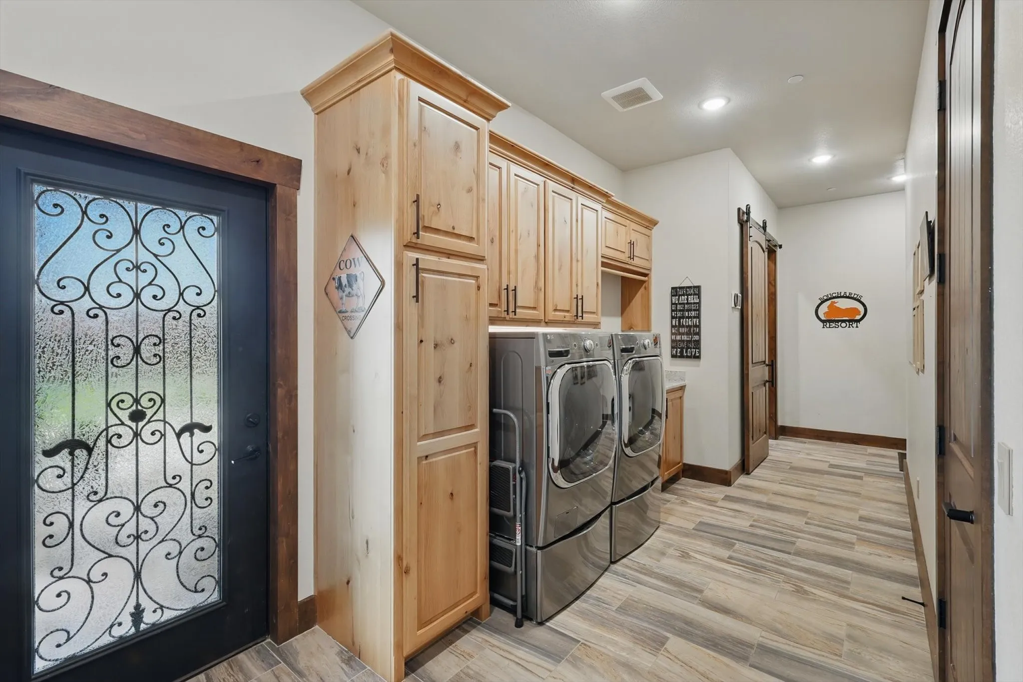 Laundry room featuring light wood-type flooring, separate washer and dryer, and cabinet space