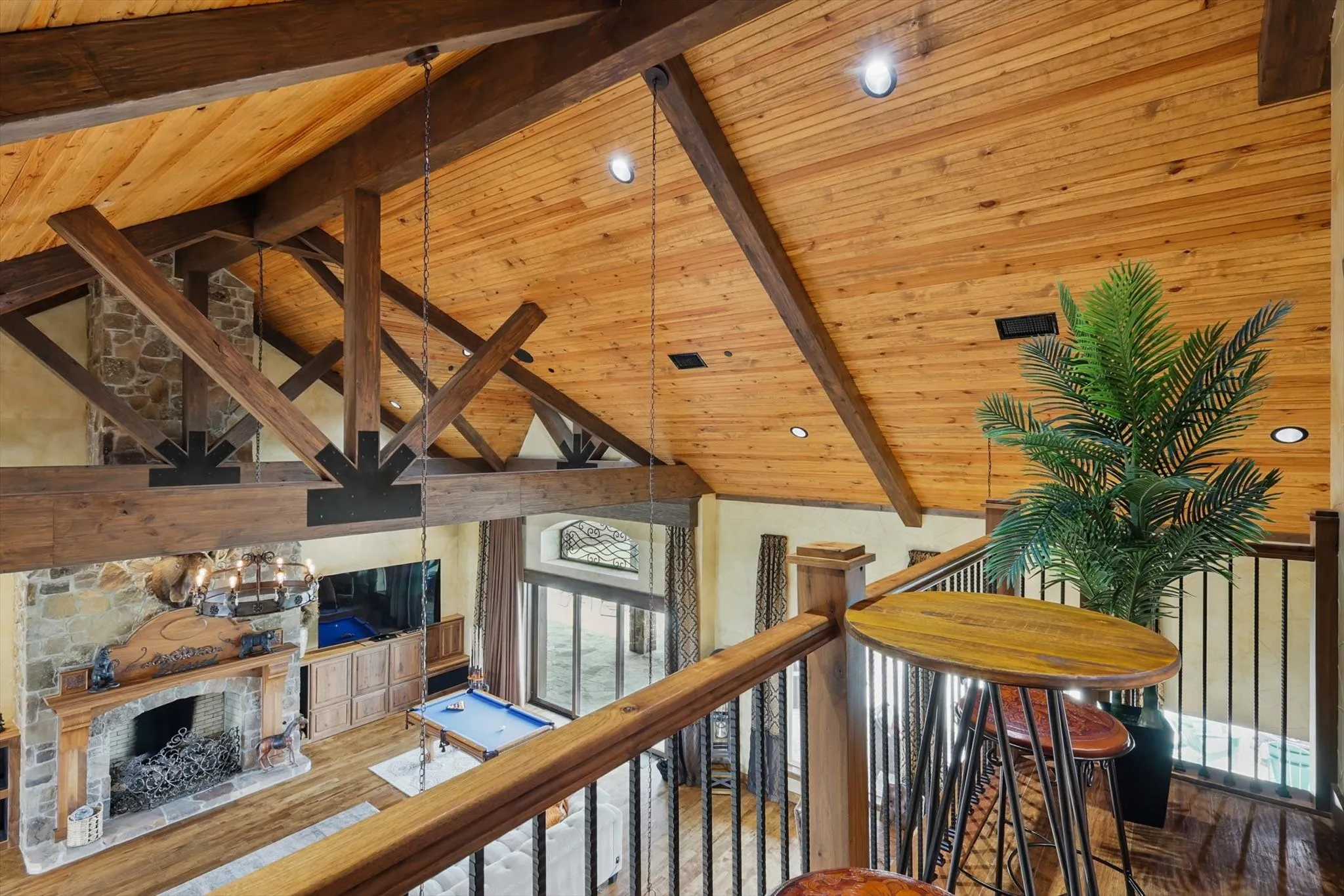 Hallway with wood finished floors, a high wood beamed ceiling, and an upstairs landing