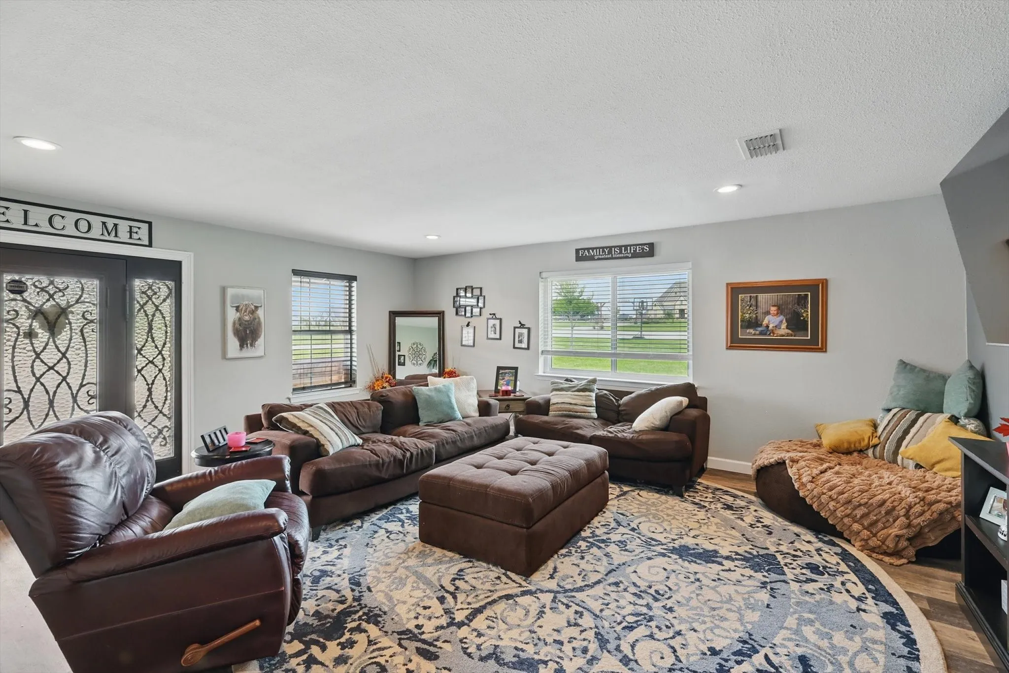 Living room featuring wood finished floors, a textured ceiling, and recessed lighting