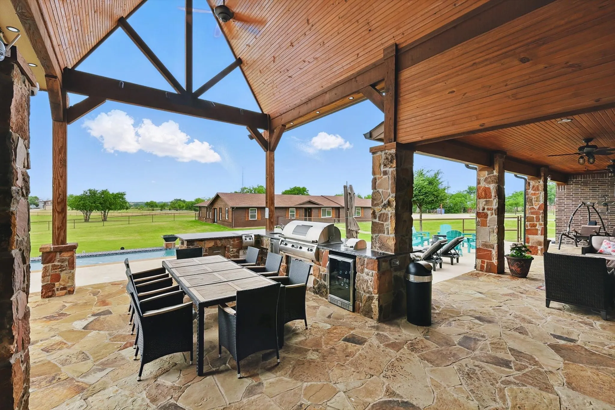 View of patio / terrace featuring an outdoor kitchen / dining area, a ceiling fan, and an outdoor pool