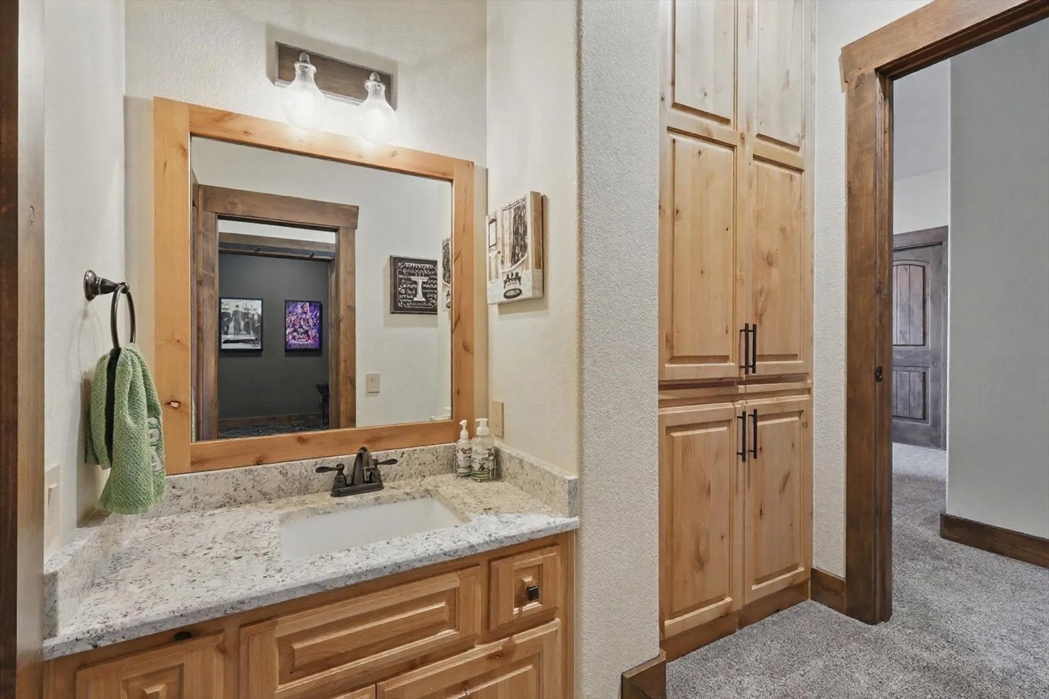 Bathroom with vanity, a textured wall, and carpet floors