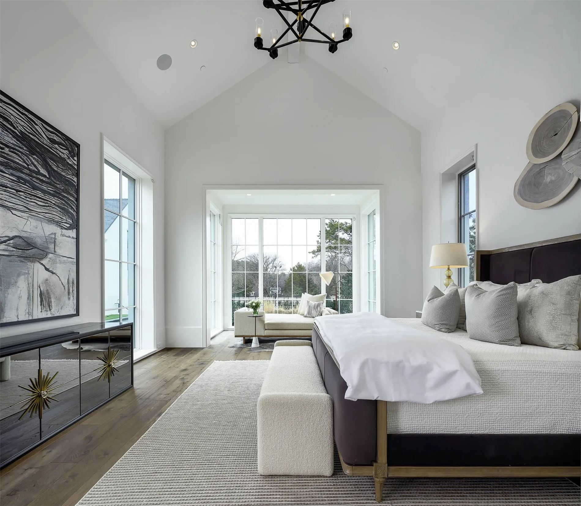 Primary bedroom with large seating area overlooking backyard