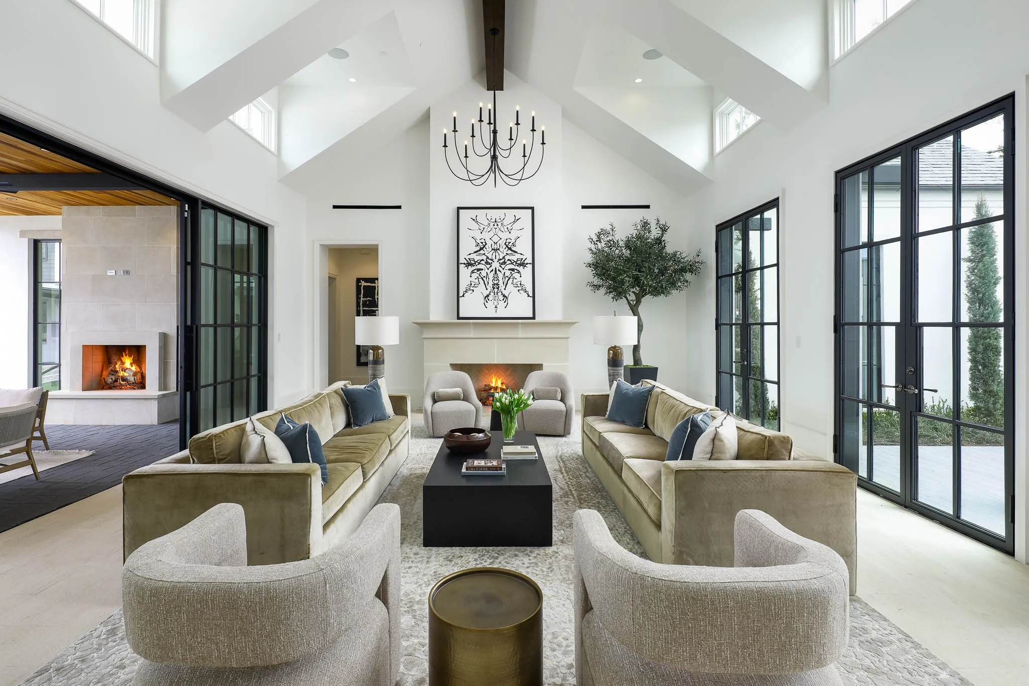Great room with gas fireplace, vaulted ceiling, and large floor to ceiling doors