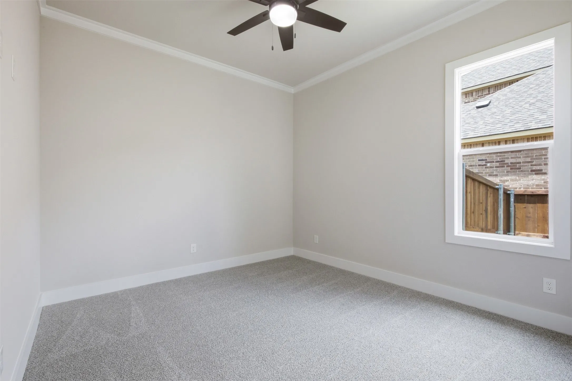 Room featuring neutral wall tones, crown molding, and a ceiling fan with light fixture