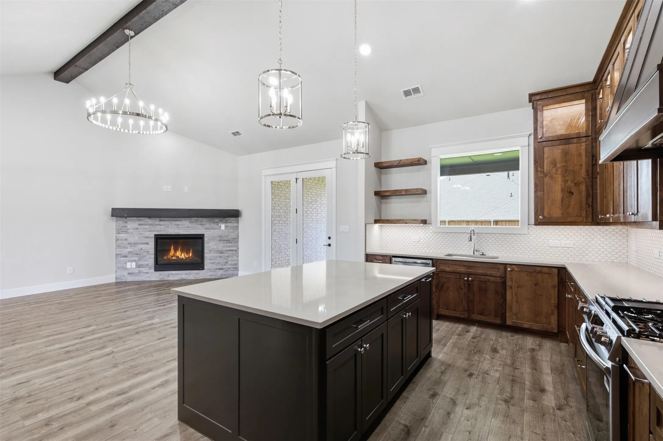 Kitchen featuring a large island with a light-toned countertop, wood-finish flooring, and shaker-style cabinetry