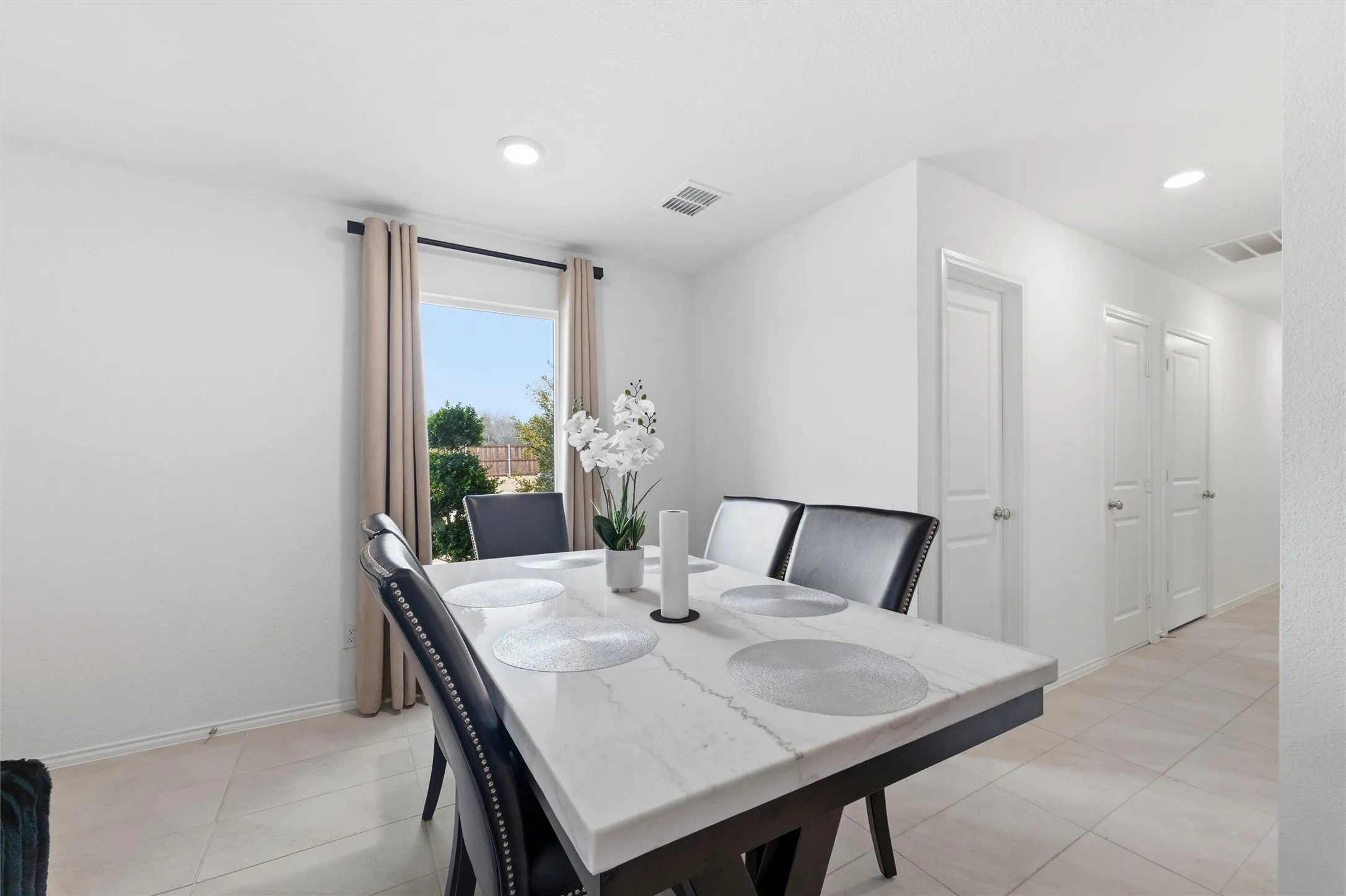 Dining room with light tile patterned floors and recessed lighting