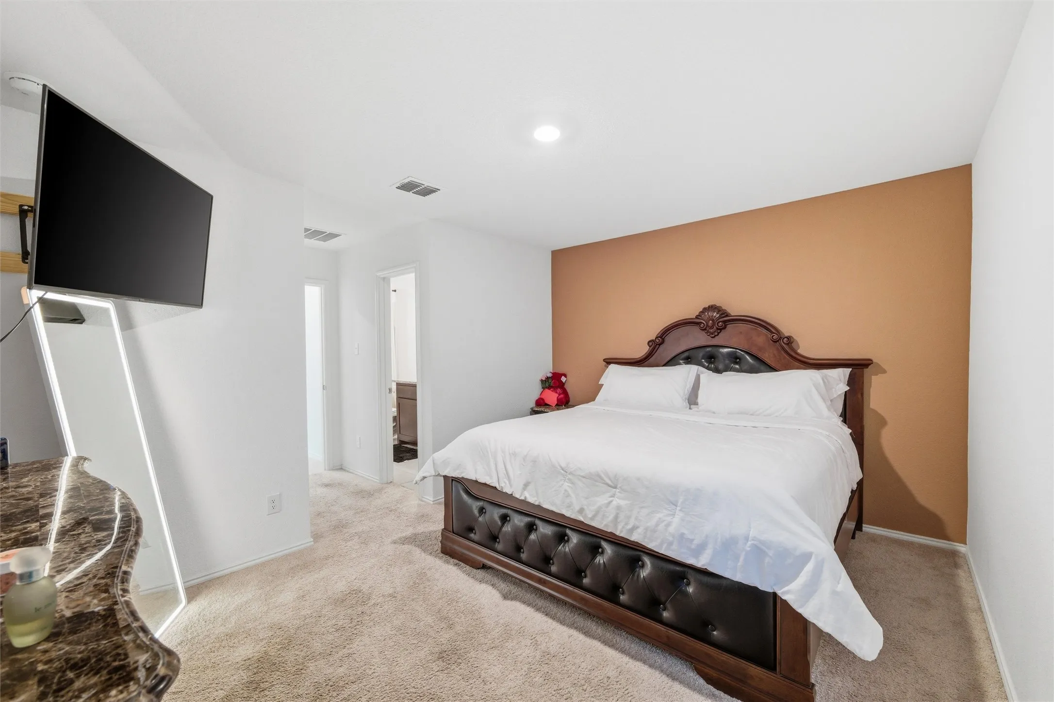 Bedroom with light colored carpet and ensuite bath