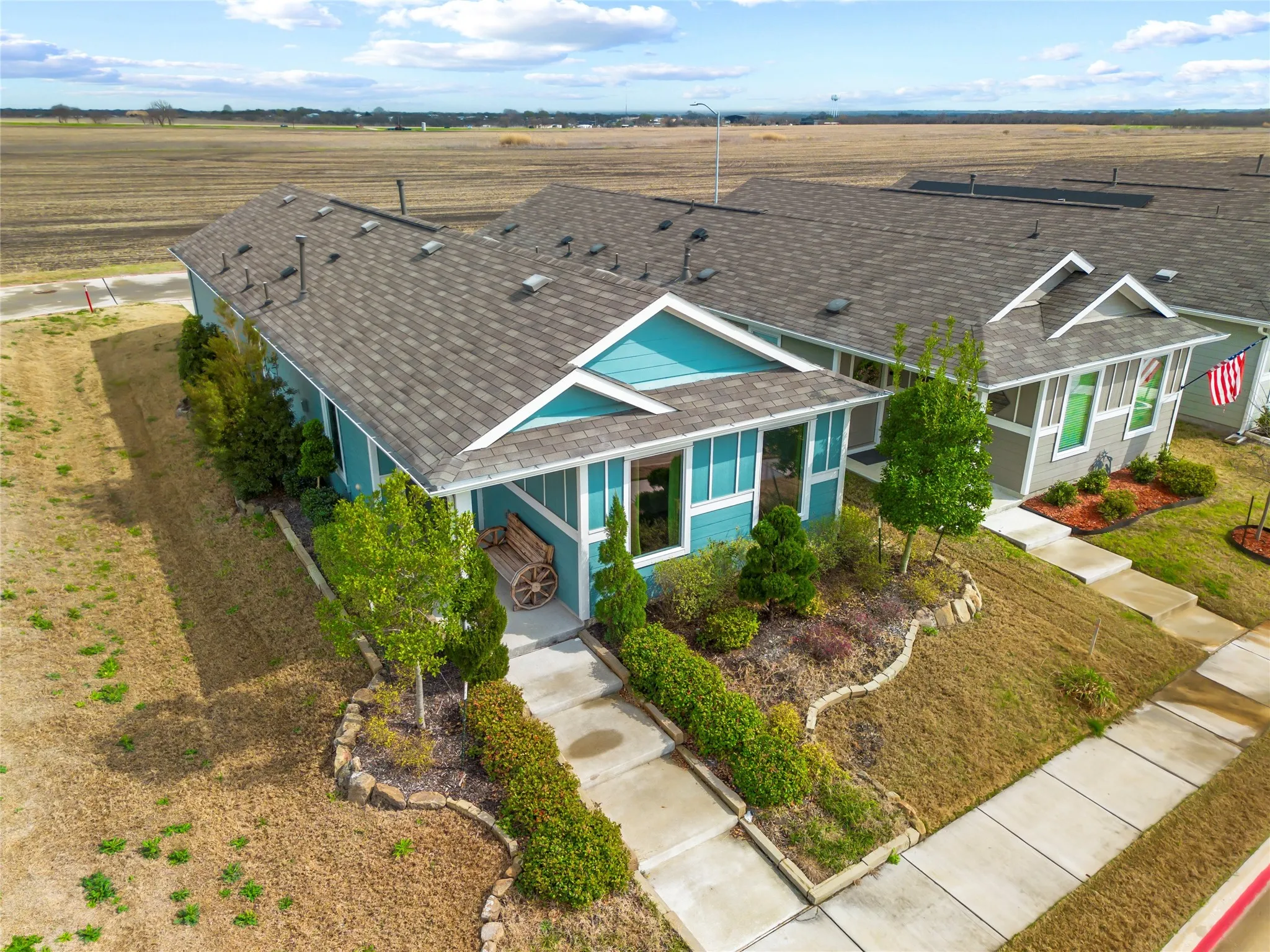 View of front facade featuring roof with shingles, a porch, and a view of rural / pastoral area
