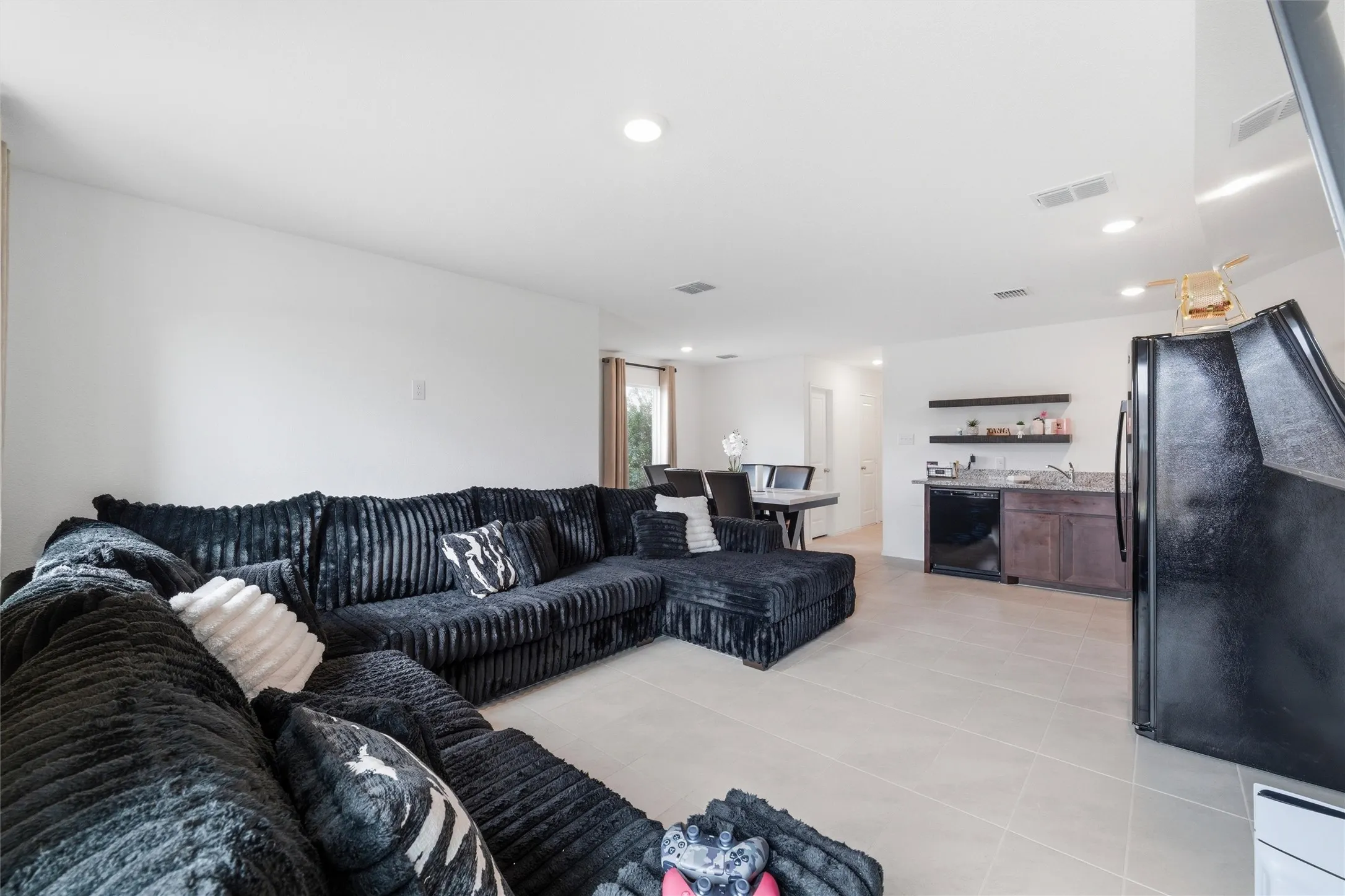 Living area with light tile patterned floors, recessed lighting, and bar