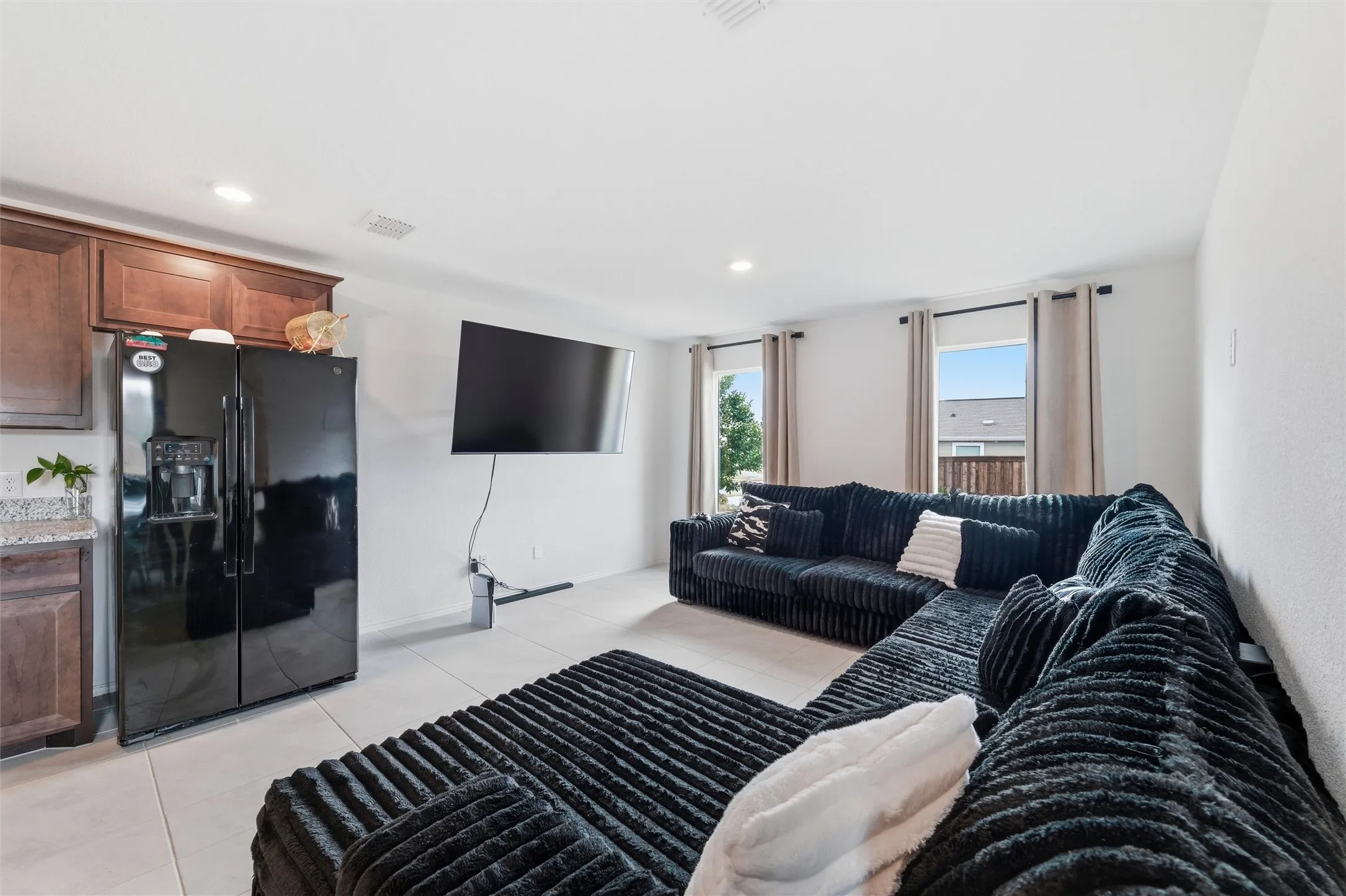 Living room with light tile patterned flooring and recessed lighting