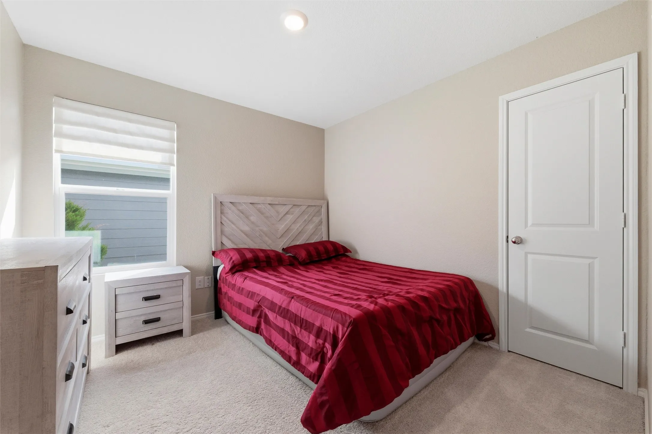 Bedroom with light colored carpet and baseboards