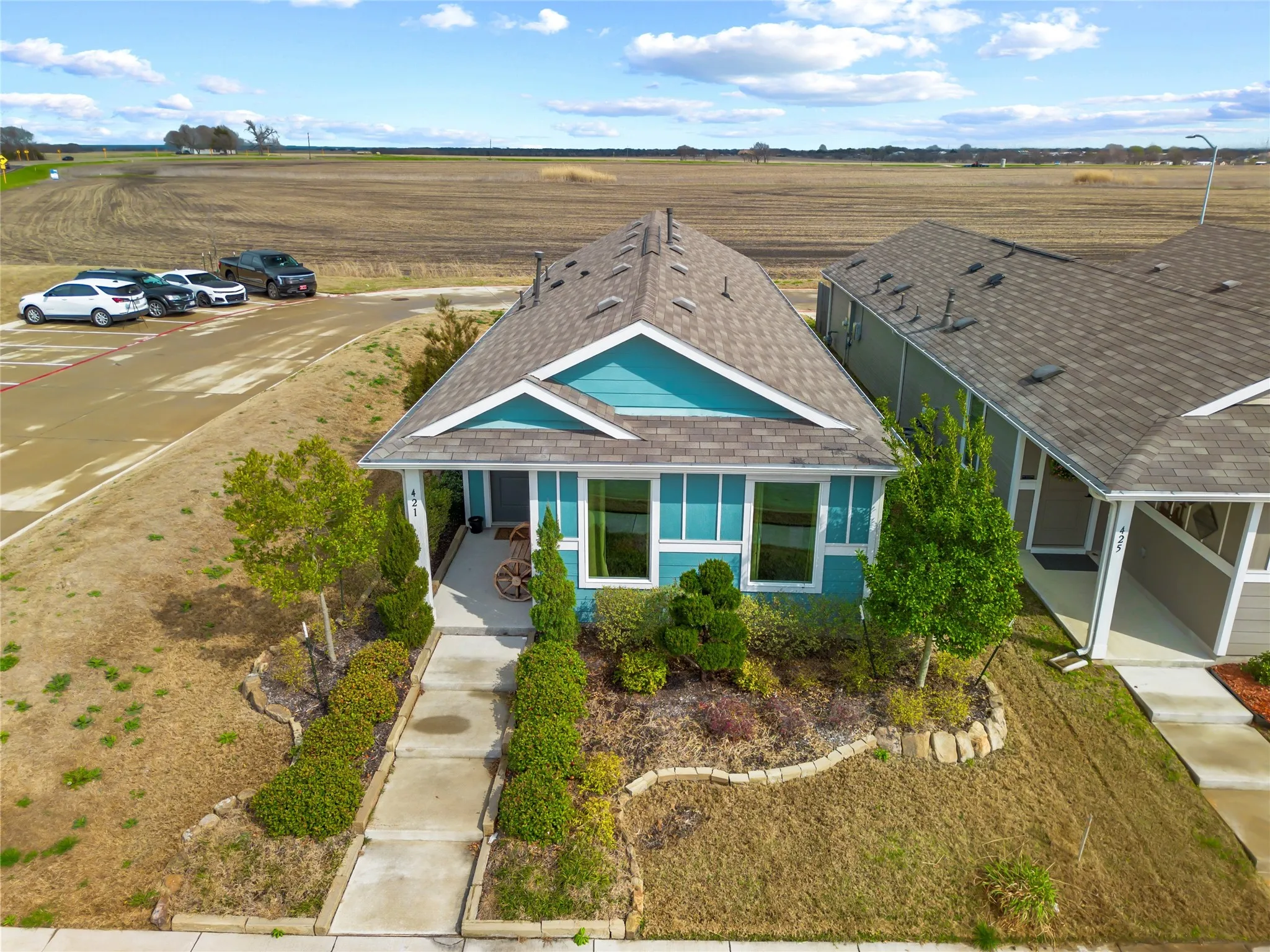 View of front of home featuring roof with shingles and a view of rural / pastoral area