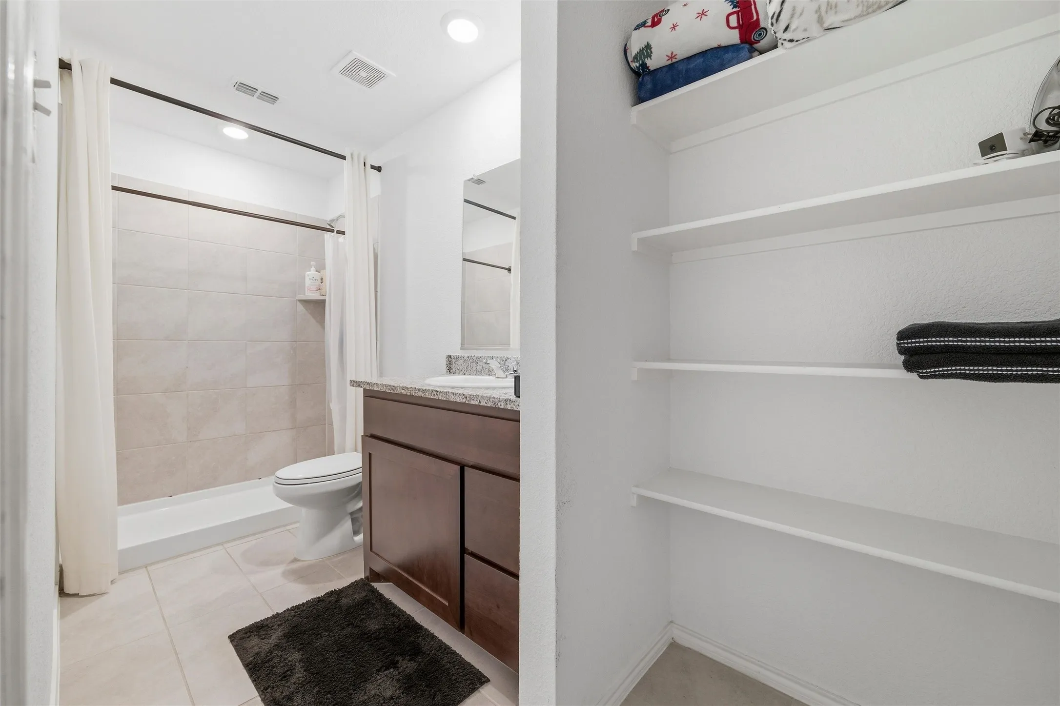 Full bathroom with vanity, light tile patterned floors, a stall shower, and recessed lighting