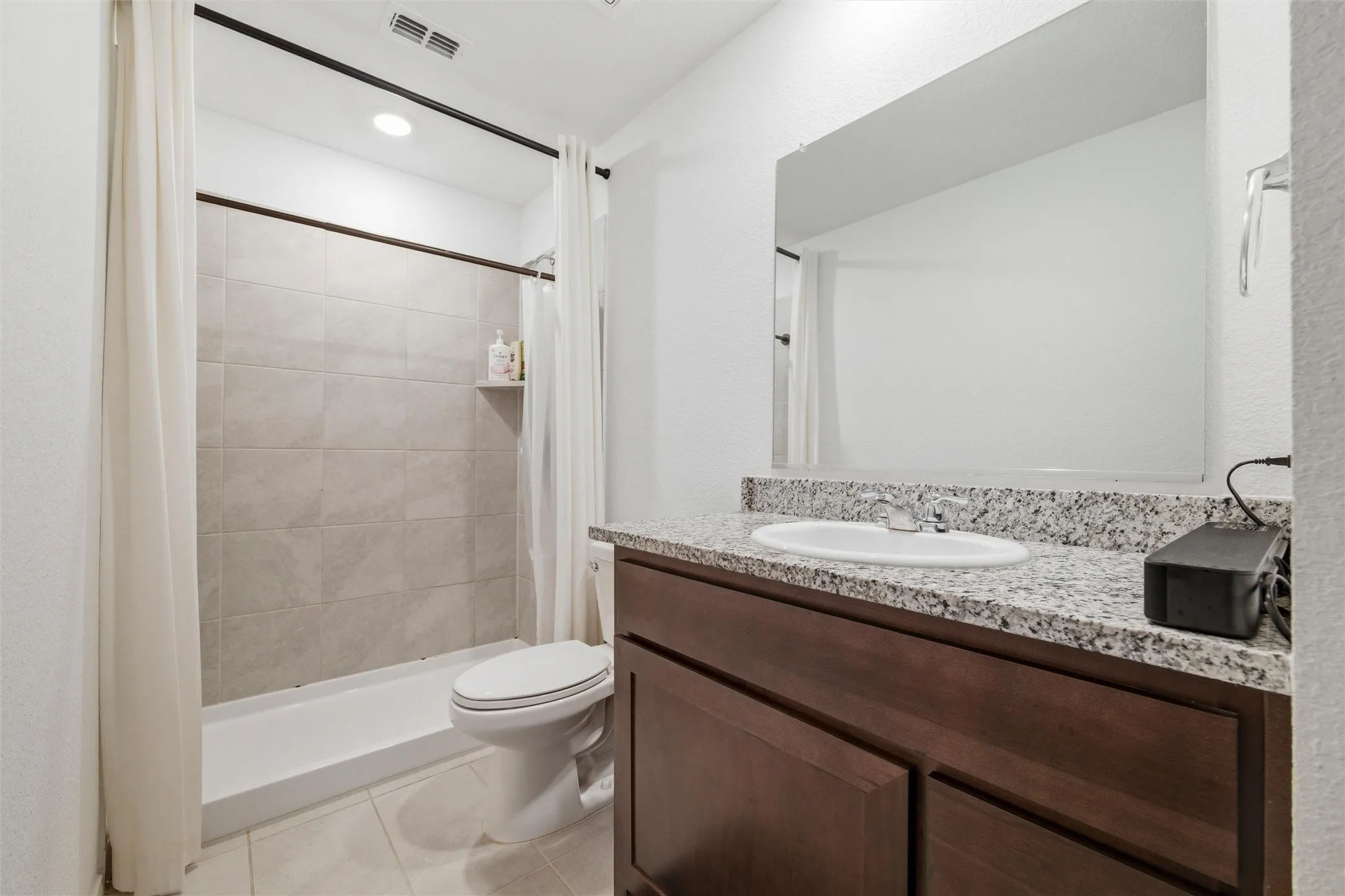 Full bath featuring vanity, a shower stall, light tile patterned floors, and recessed lighting