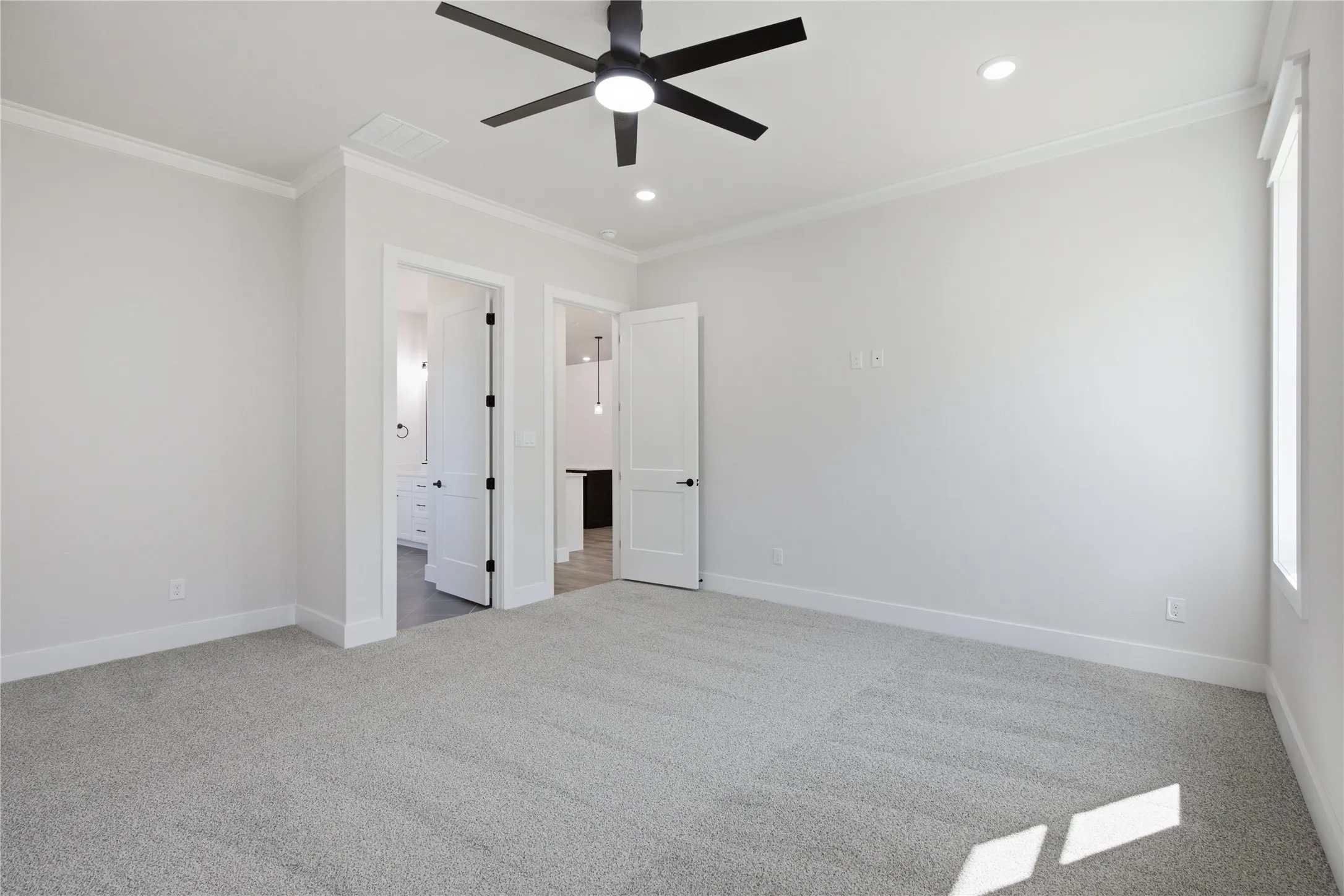 Recessed lighting, ceiling fan, crown molding, white doors, and light gray carpet