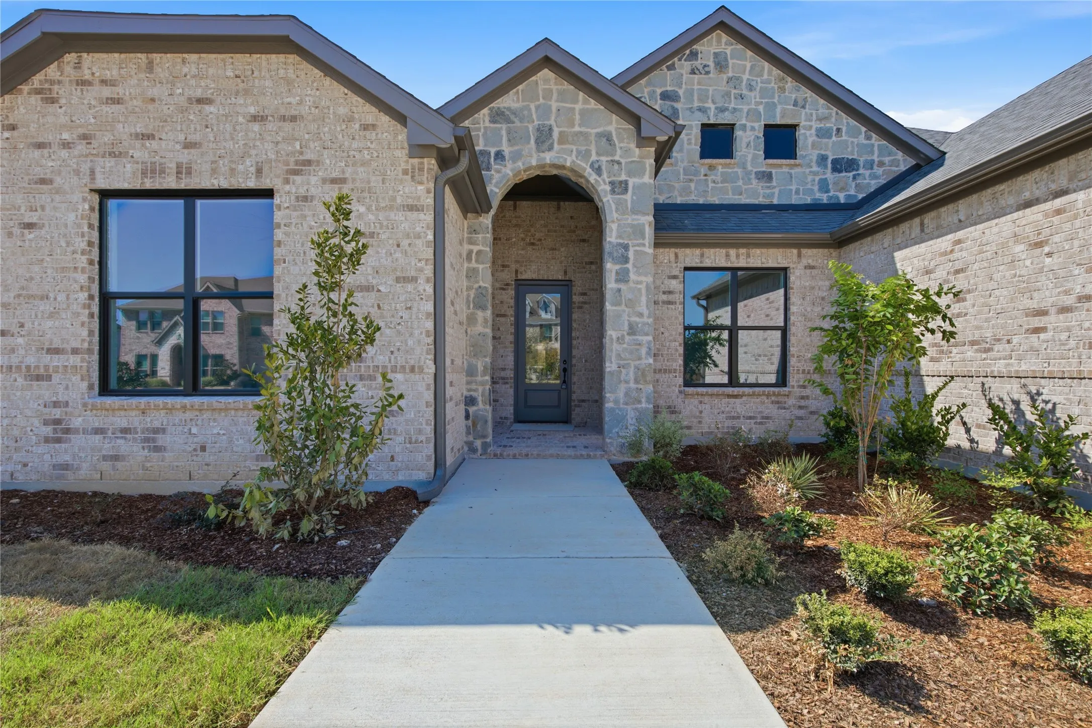 Stone and brick exterior with dark trim windows