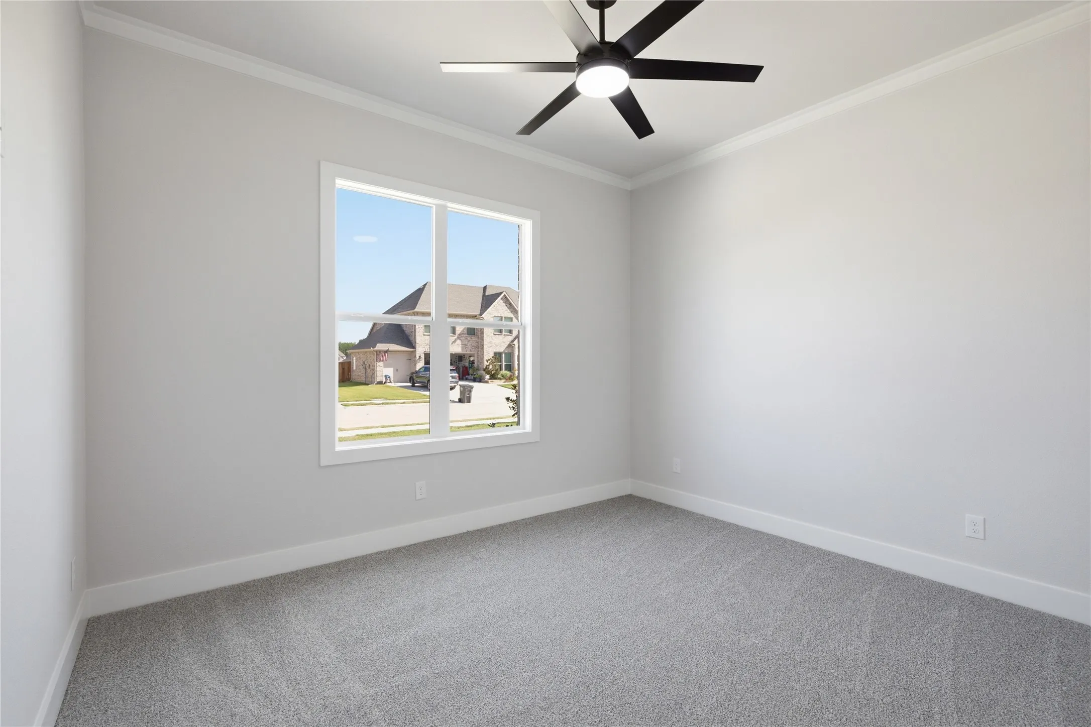 Recessed window with white trim, gray wall paint, crown molding, gray carpet flooring, and a ceiling fan with integrated lighting