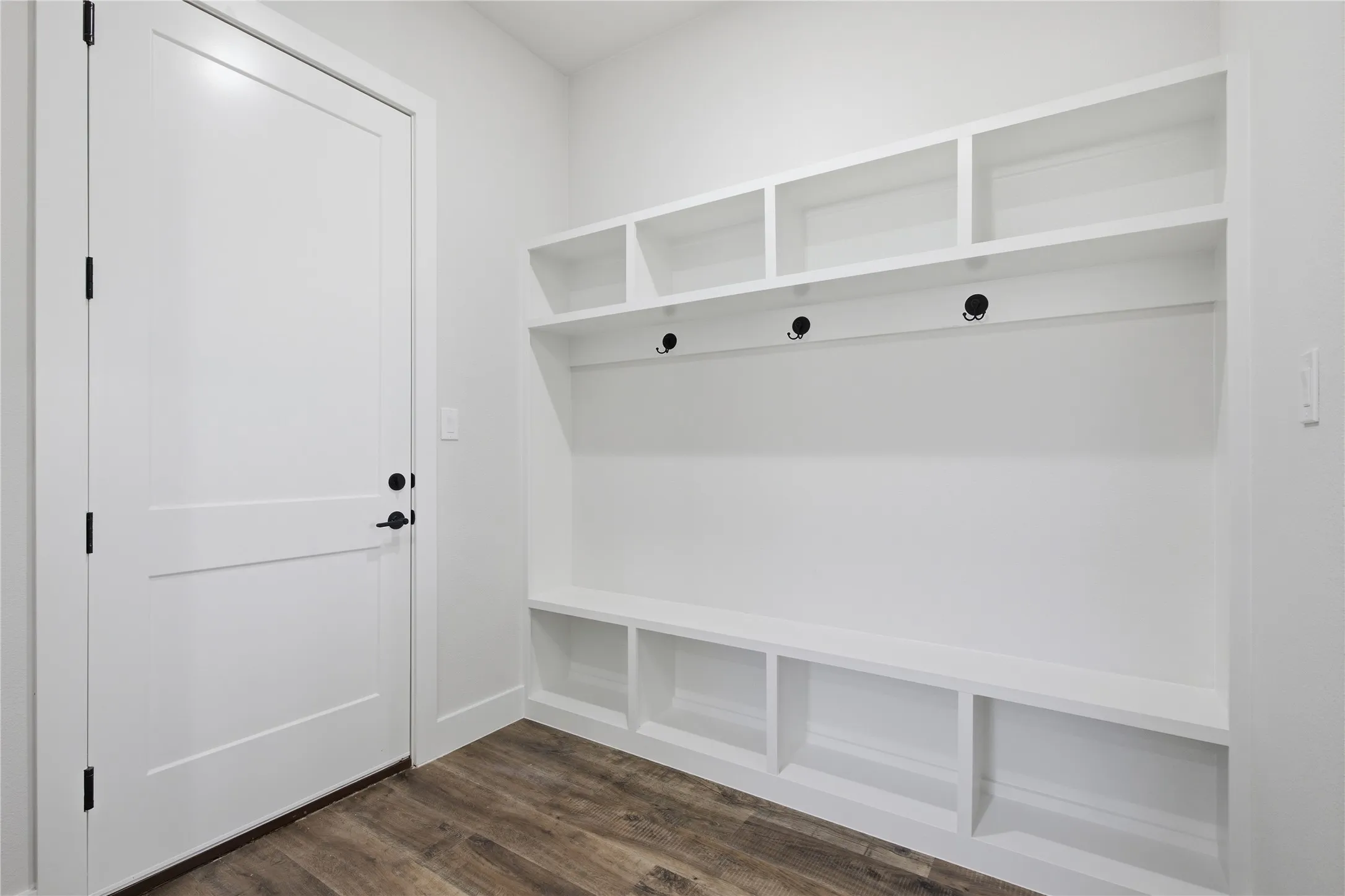 Built-in storage bench with overhead shelving and integrated hooks