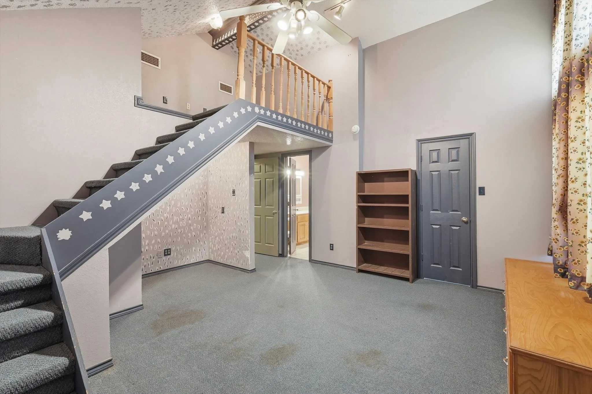 Unfurnished living room with a high ceiling, light colored carpet, and ceiling fan