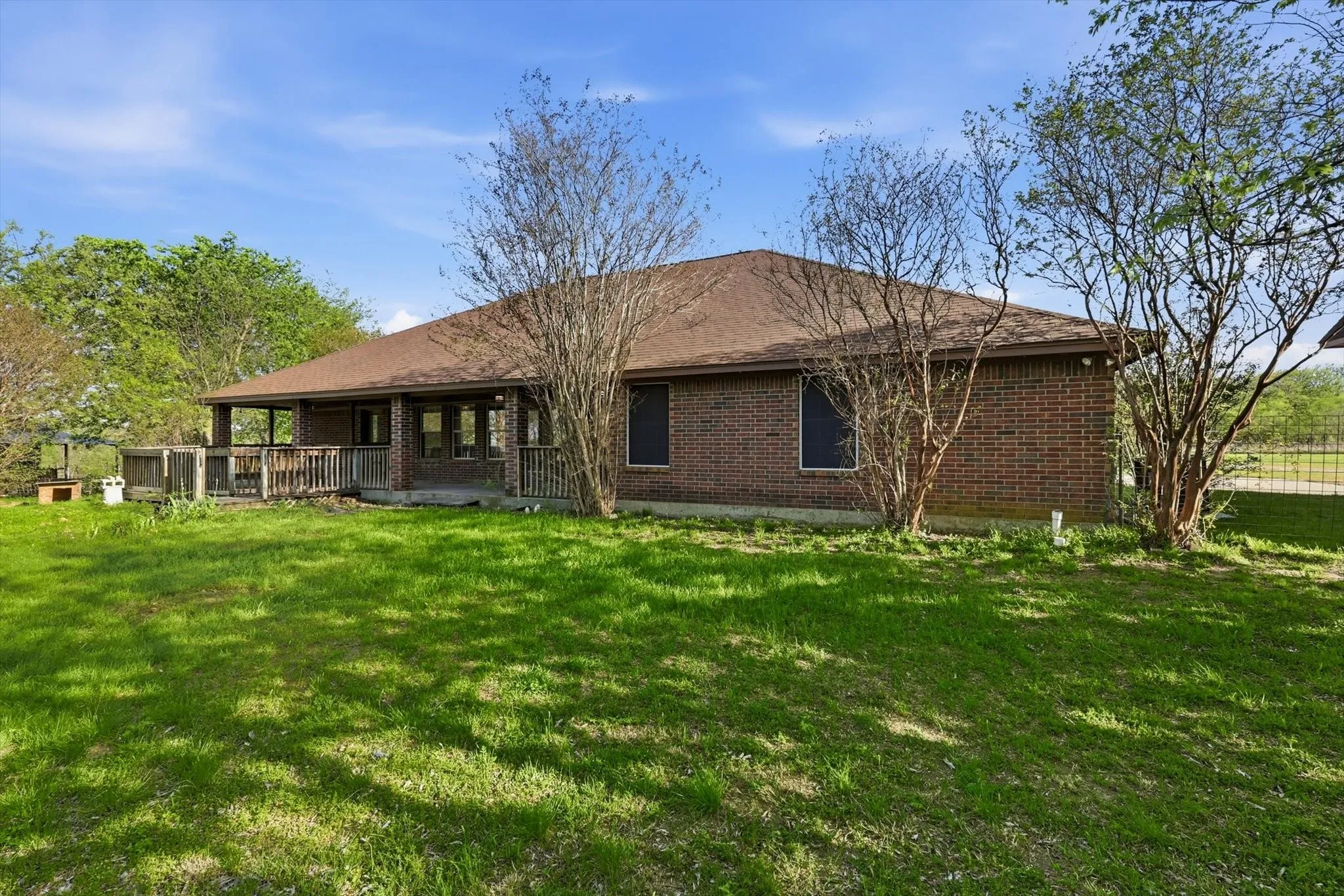 Rear view of house with brick siding and a lawn