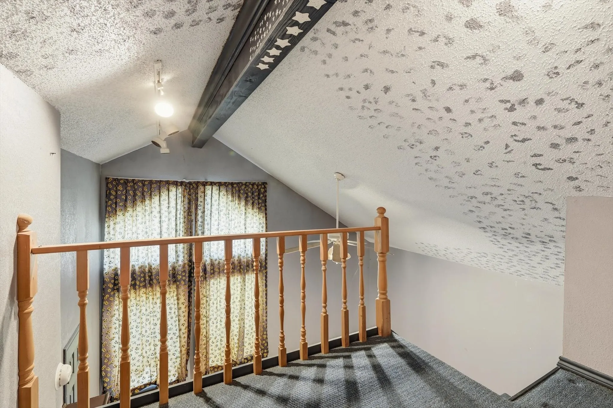 Stairs with beamed ceiling, carpet floors, and a textured ceiling