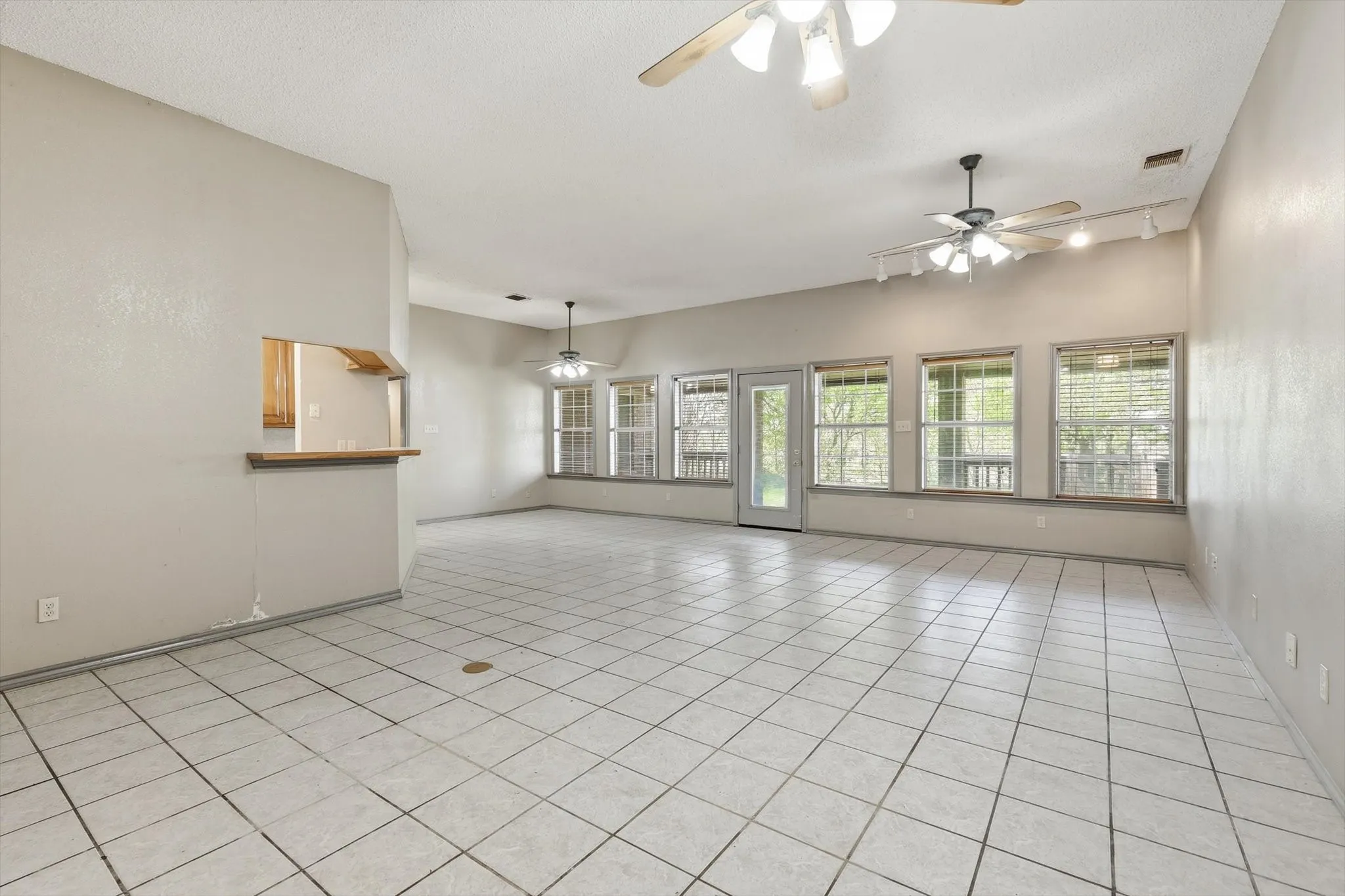 Spare room with light tile patterned flooring, a textured ceiling, and a ceiling fan