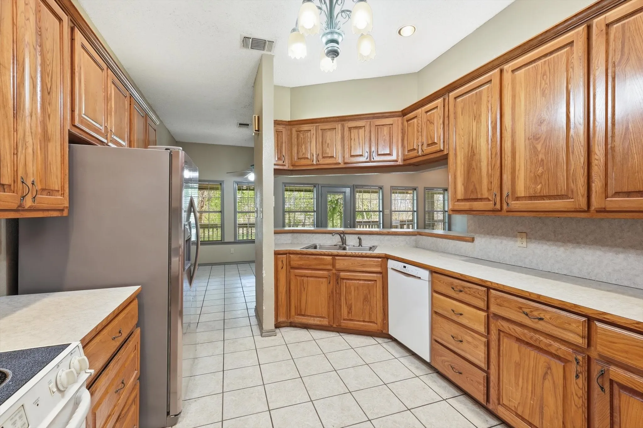 Kitchen featuring light countertops, wood finish cabinetry, and light tile patterned floors