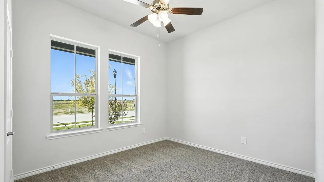 Unfurnished room with a ceiling fan and dark carpet