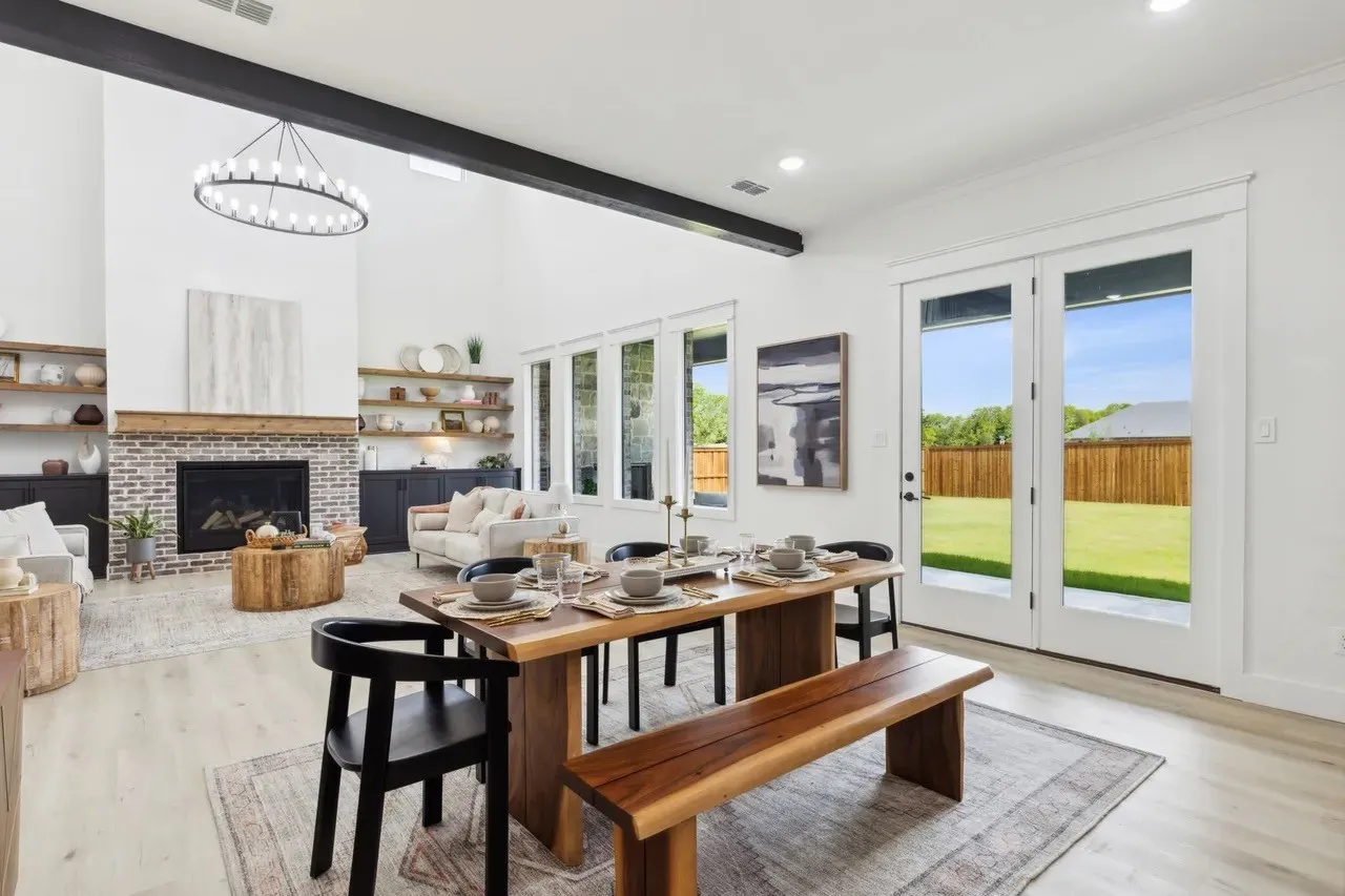 Dining space with light wood-type flooring, a brick fireplace, and suspended lighting