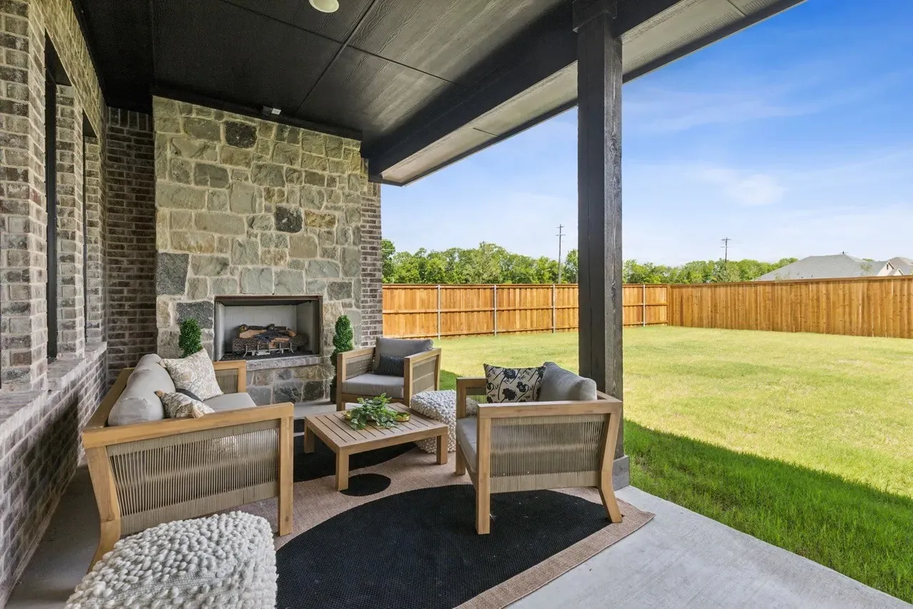 Fenced backyard with a patio area and an outdoor living space with a fireplace