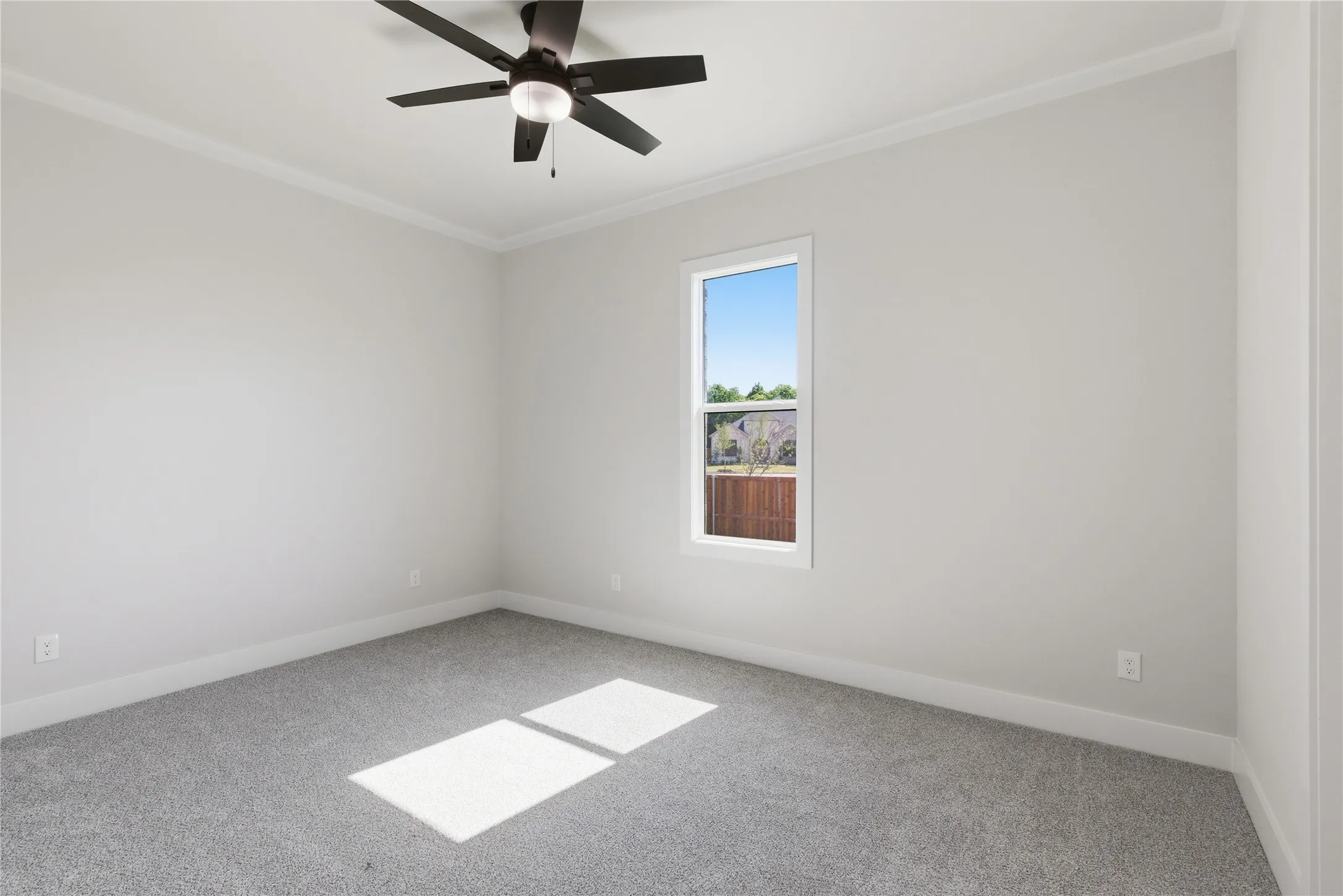 Bedroom featuring light gray carpeting, neutral wall paint, a ceiling fan with integrated lighting, a single window, and white crown molding