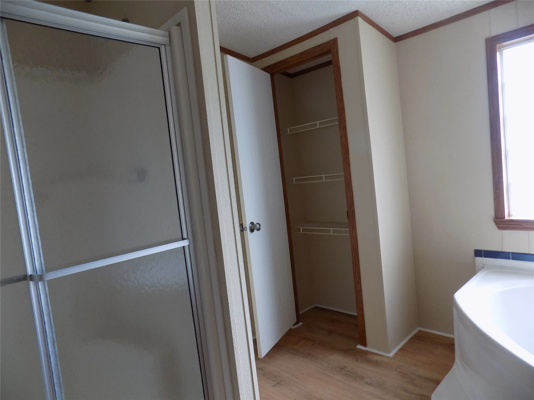 Primary bathroom with shower stall, garden tub, linen closet and healthy amount of natural light.