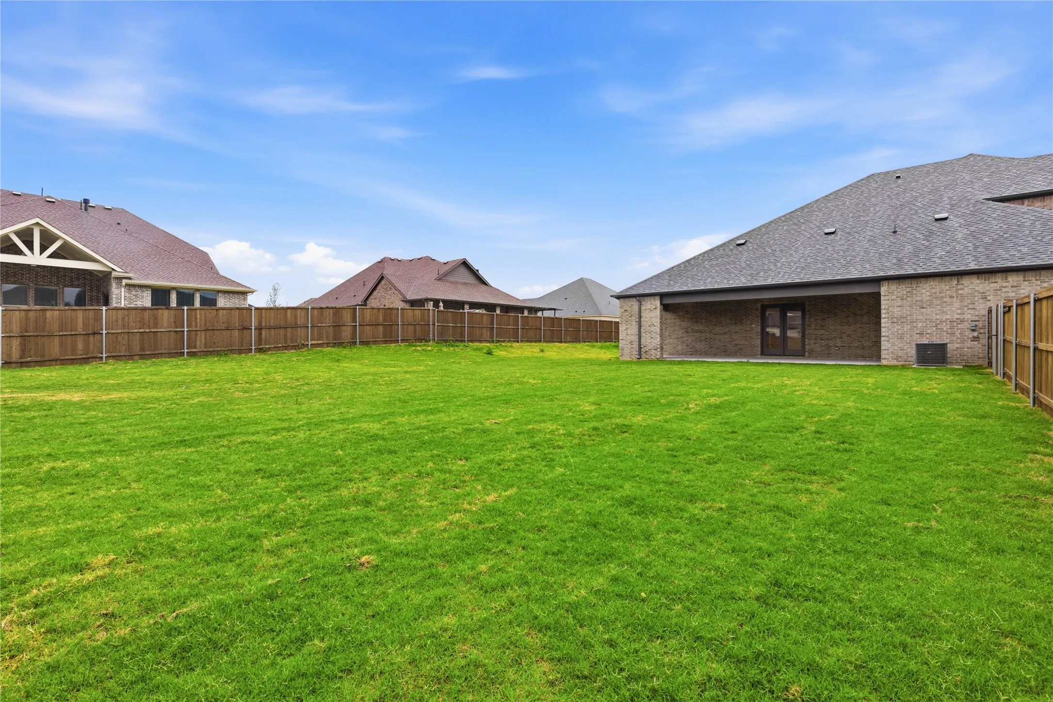 Expansive green lawn with a wood privacy fence