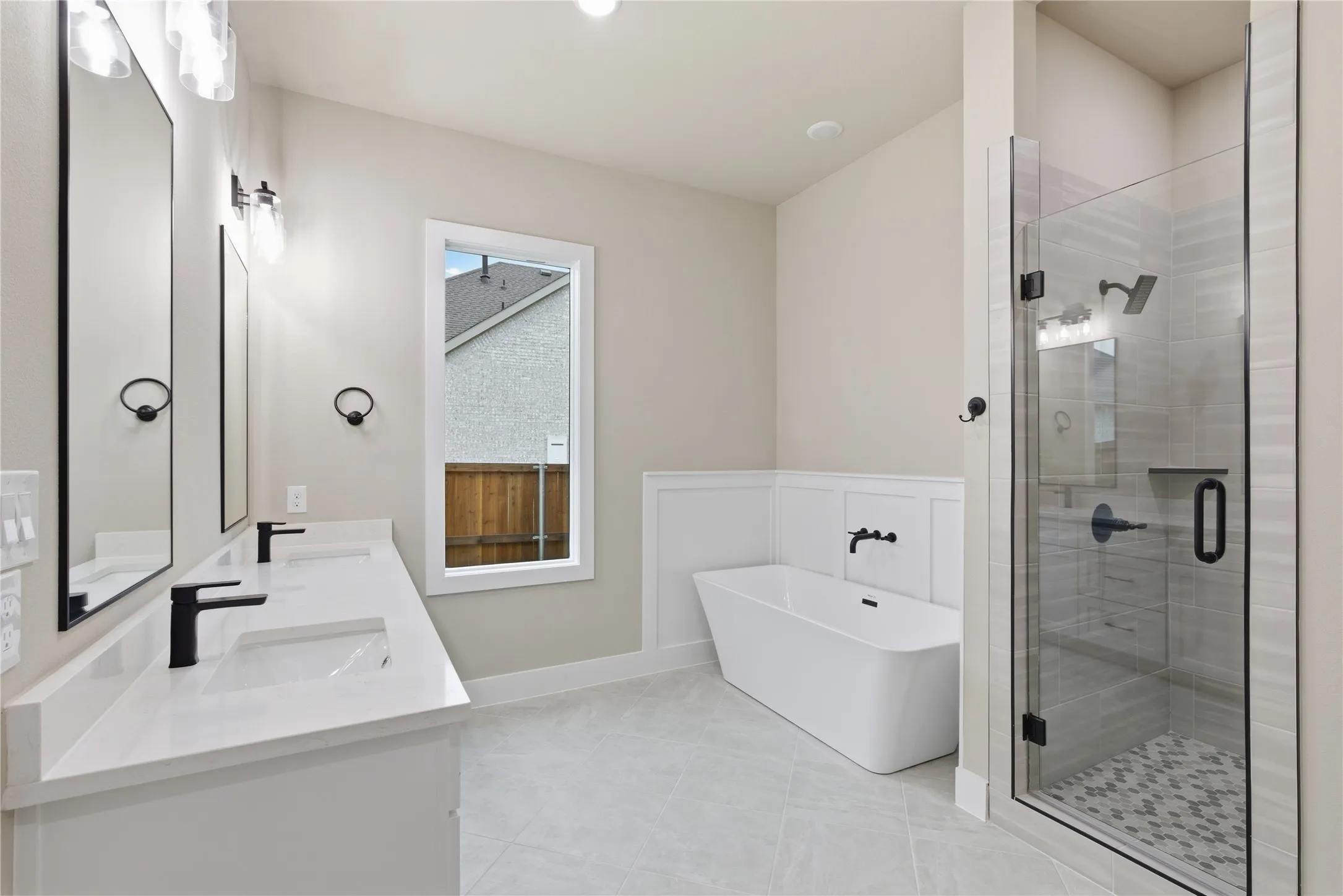 Modern bathroom featuring a dual vanity with rectangular sinks, quartz countertops, and matte black fixtures
